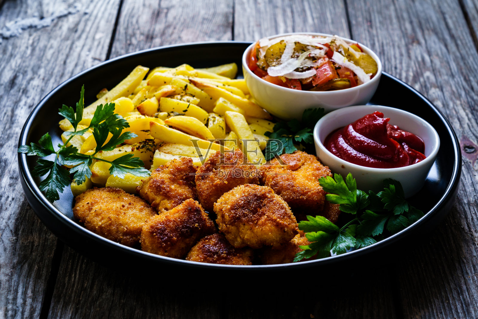 炸鸡块配薯条和蔬菜沙拉放在木桌上照片摄影图片
