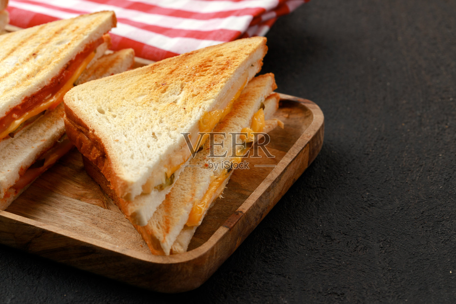 三明治用餐巾在木板上切成两半照片摄影图片