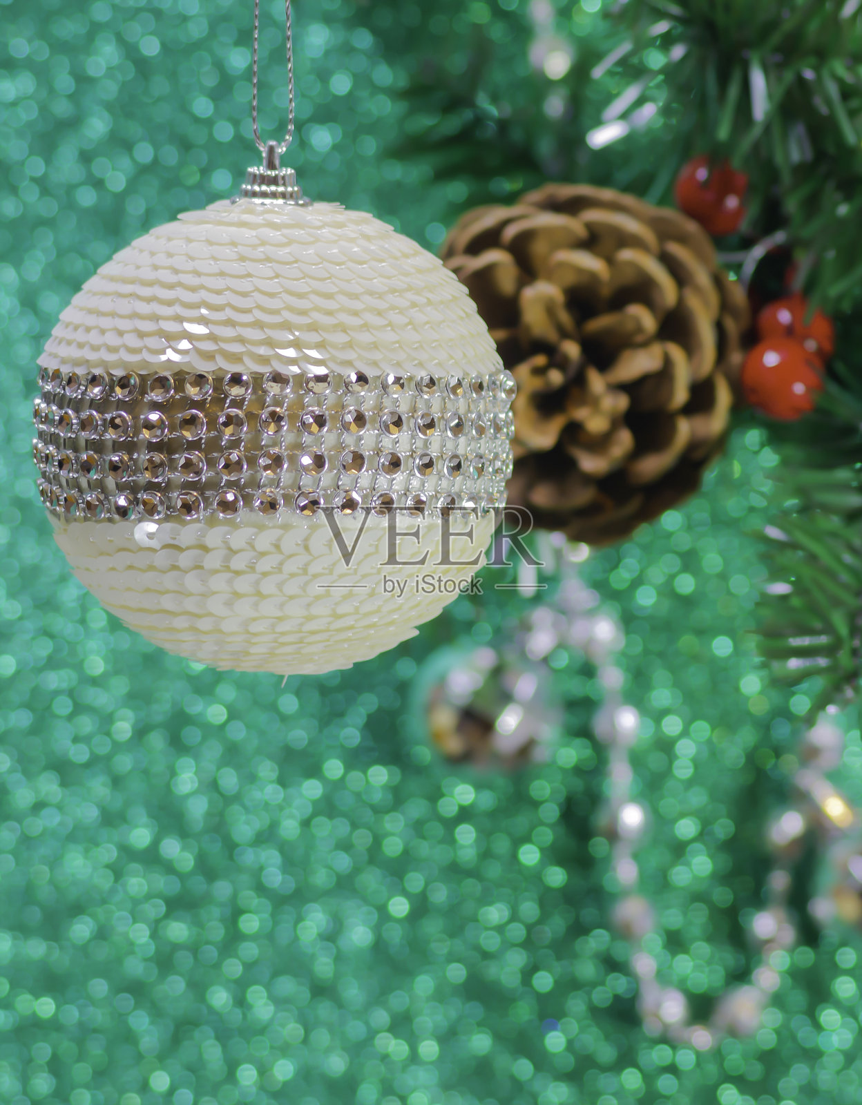 白色圣诞球在一个圣诞树枝和绿色的散焦背景照片摄影图片