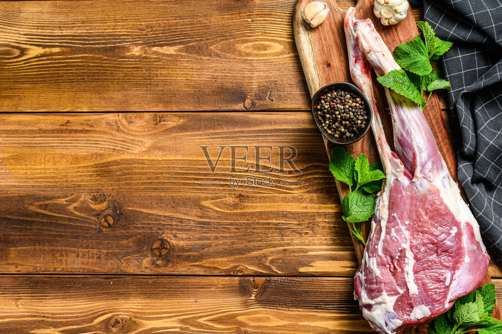 羊腿配香草。生有机肉类。木制背景。前视图。本空间照片摄影图片