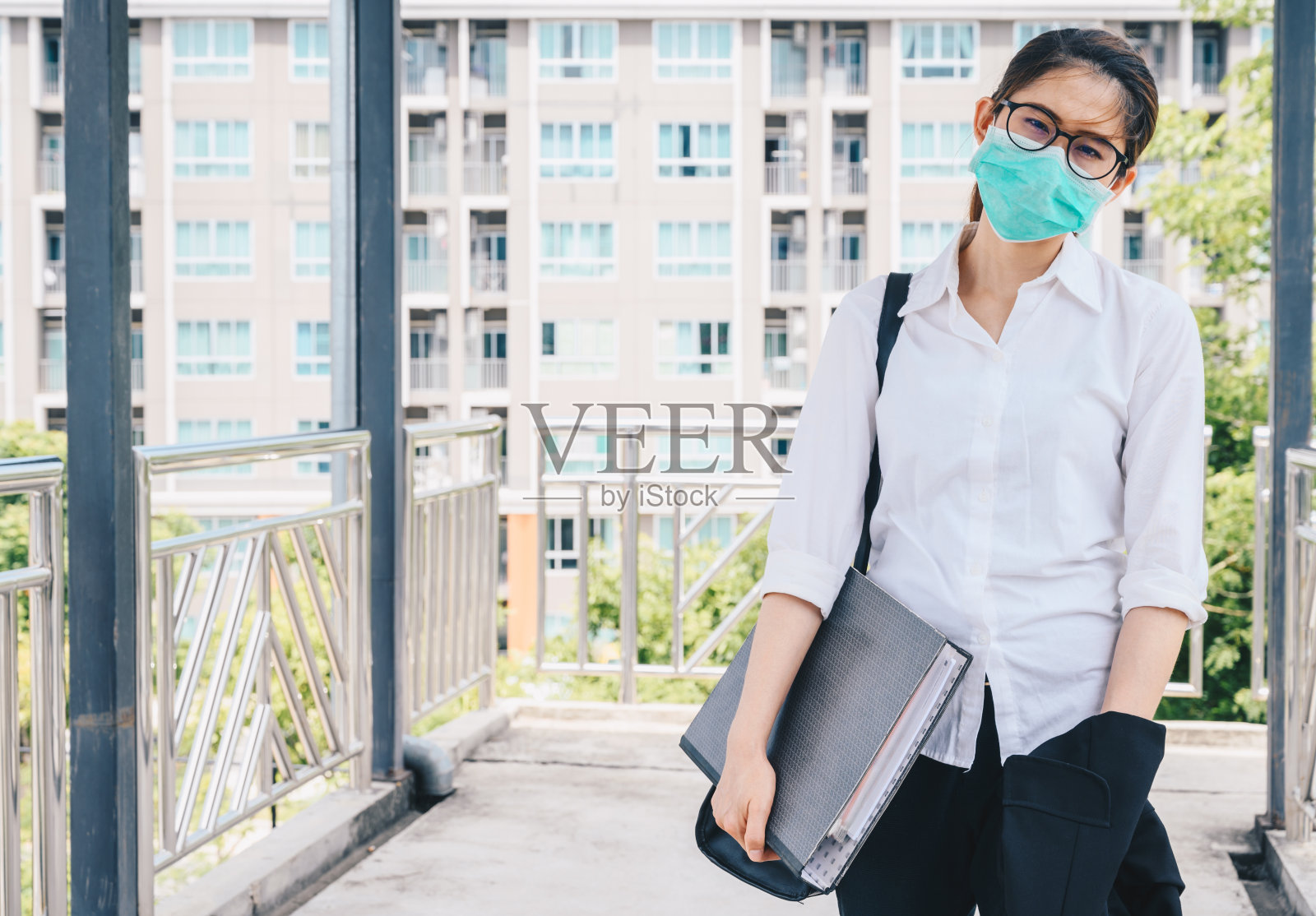 2019冠状病毒病大流行期间,亚洲年轻女商人外出工作时戴口罩防护病毒。照片摄影图片