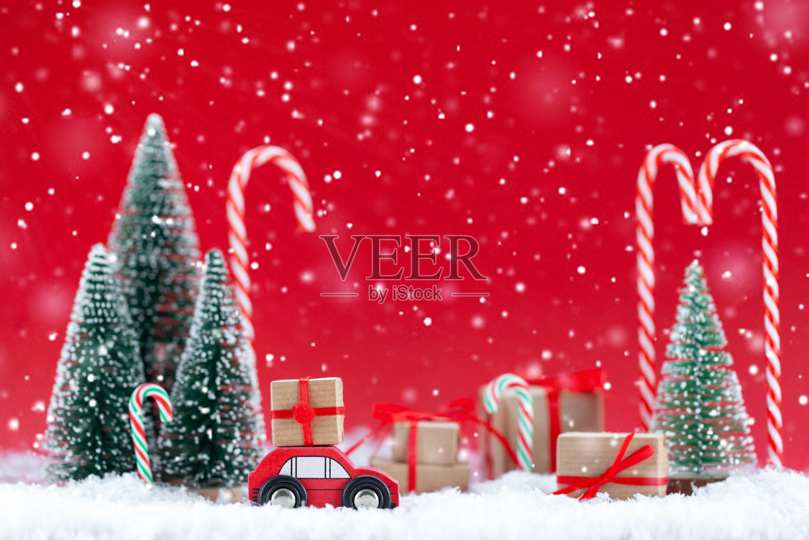 节日构图圣诞红车与礼盒在松林里许多不同的礼物在红色的背景。新年贺卡的概念照片摄影图片