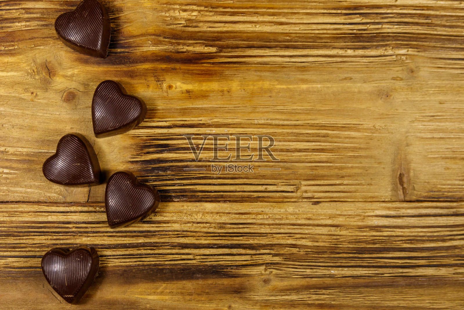 心形巧克力糖果在木制的背景。俯视图,复制空间。情人节的概念照片摄影图片