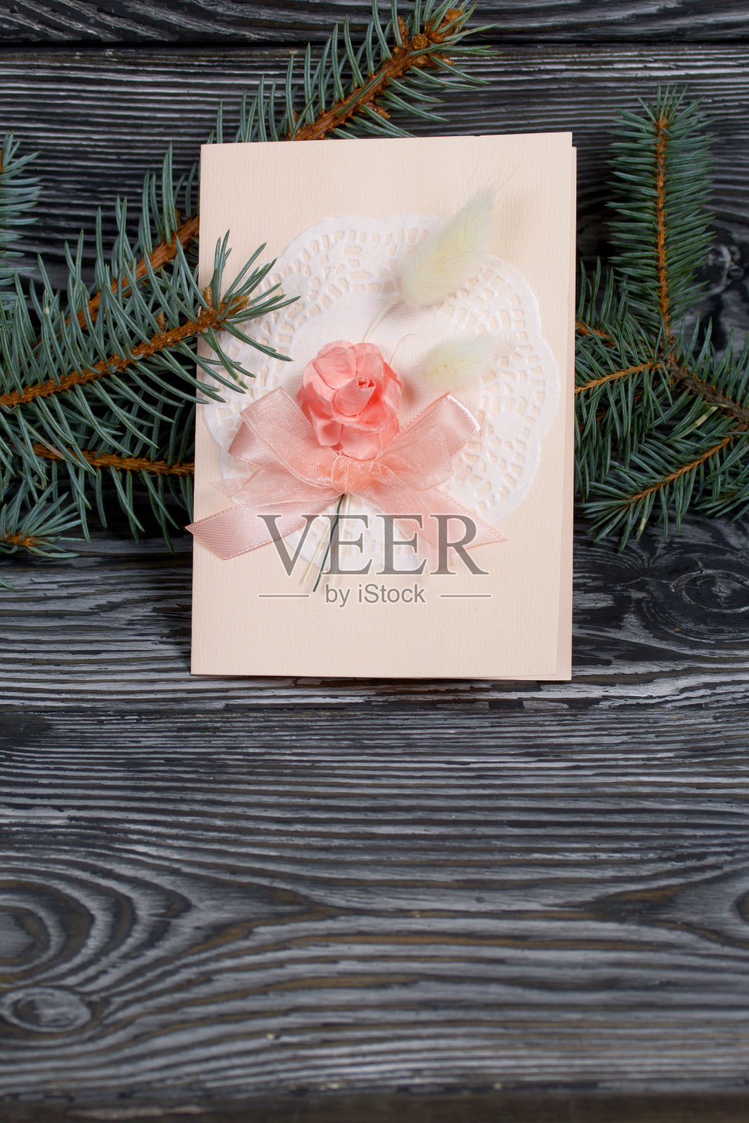 带有粉色阴影元素的贺卡。云杉分支。在黑色的松木板上。照片摄影图片