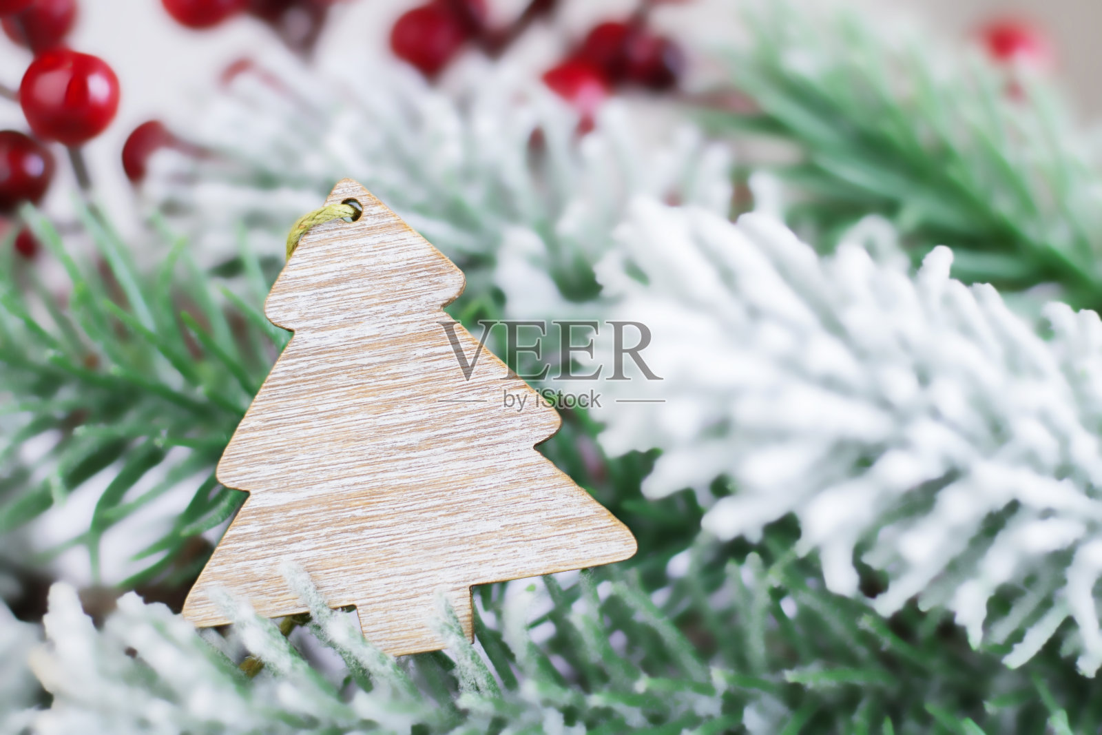 圣诞树上的木质吊坠。圣诞装饰的冷杉背景上模糊的冷杉与雪。圣诞节或新年的明信片。本空间照片摄影图片