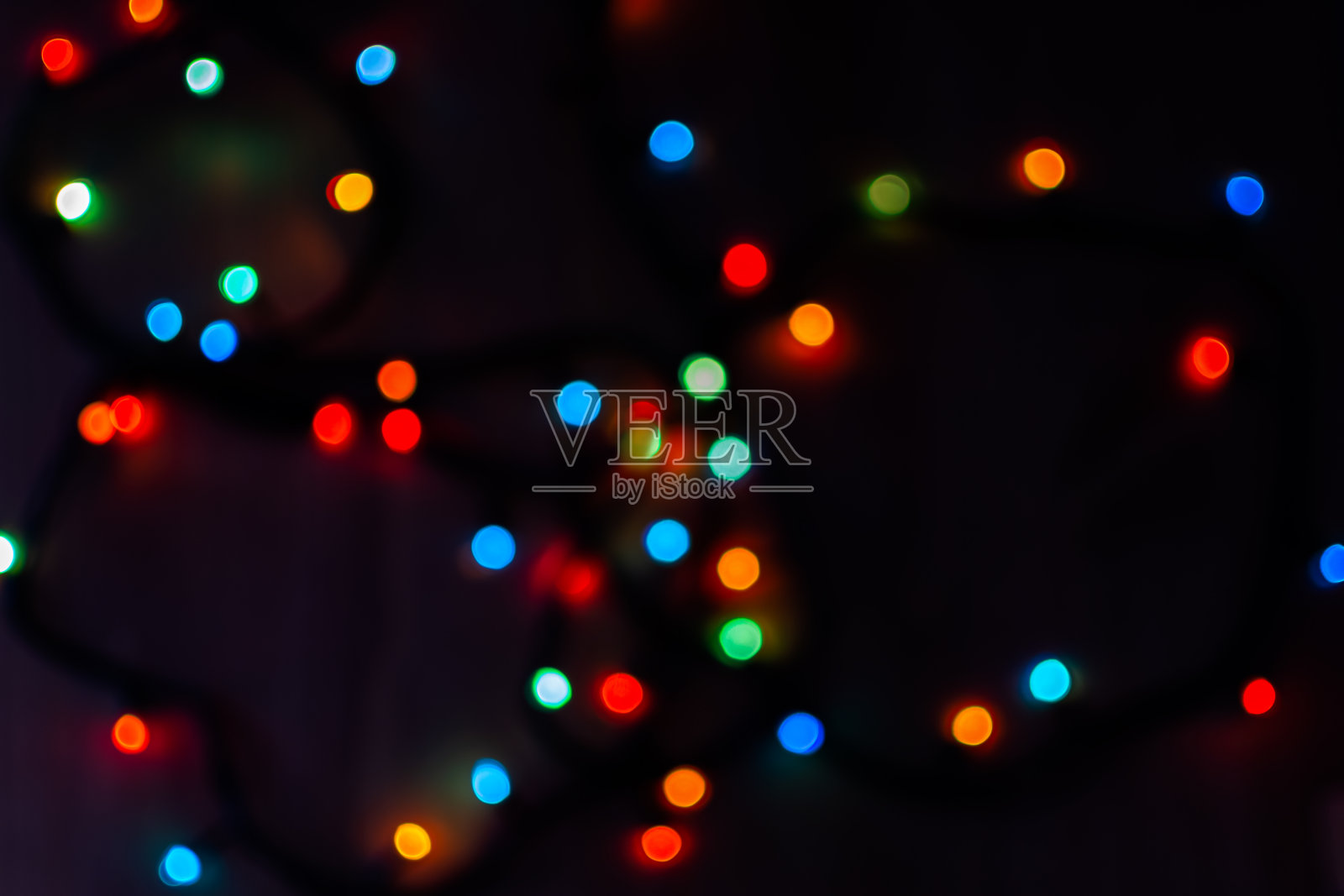 黑色背景上的多色散景。明亮模糊的节日灯光纹理。照片摄影图片