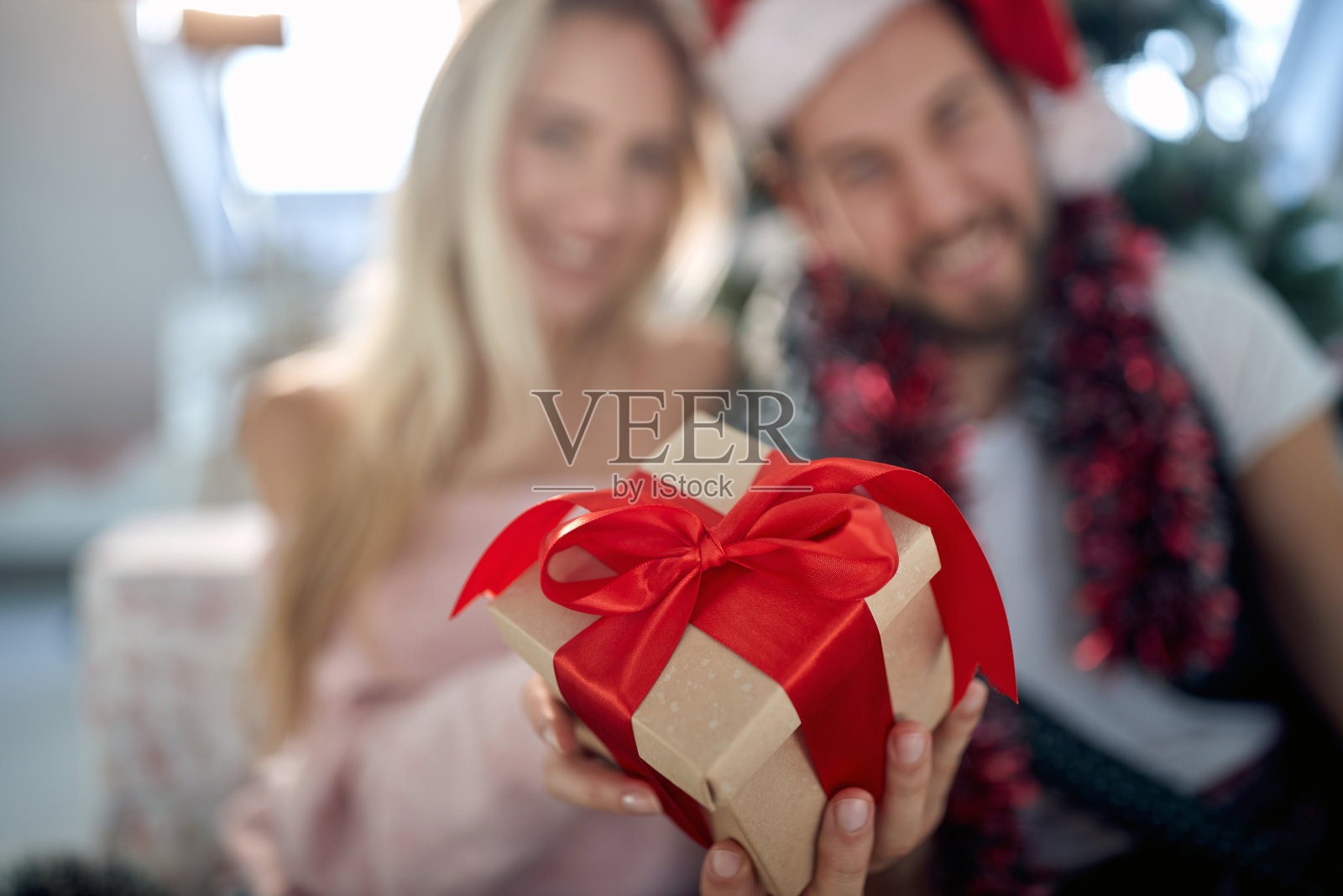 一对可爱的夫妇带着圣诞礼物在家摆姿势拍照。圣诞节,关系,爱,相聚照片摄影图片