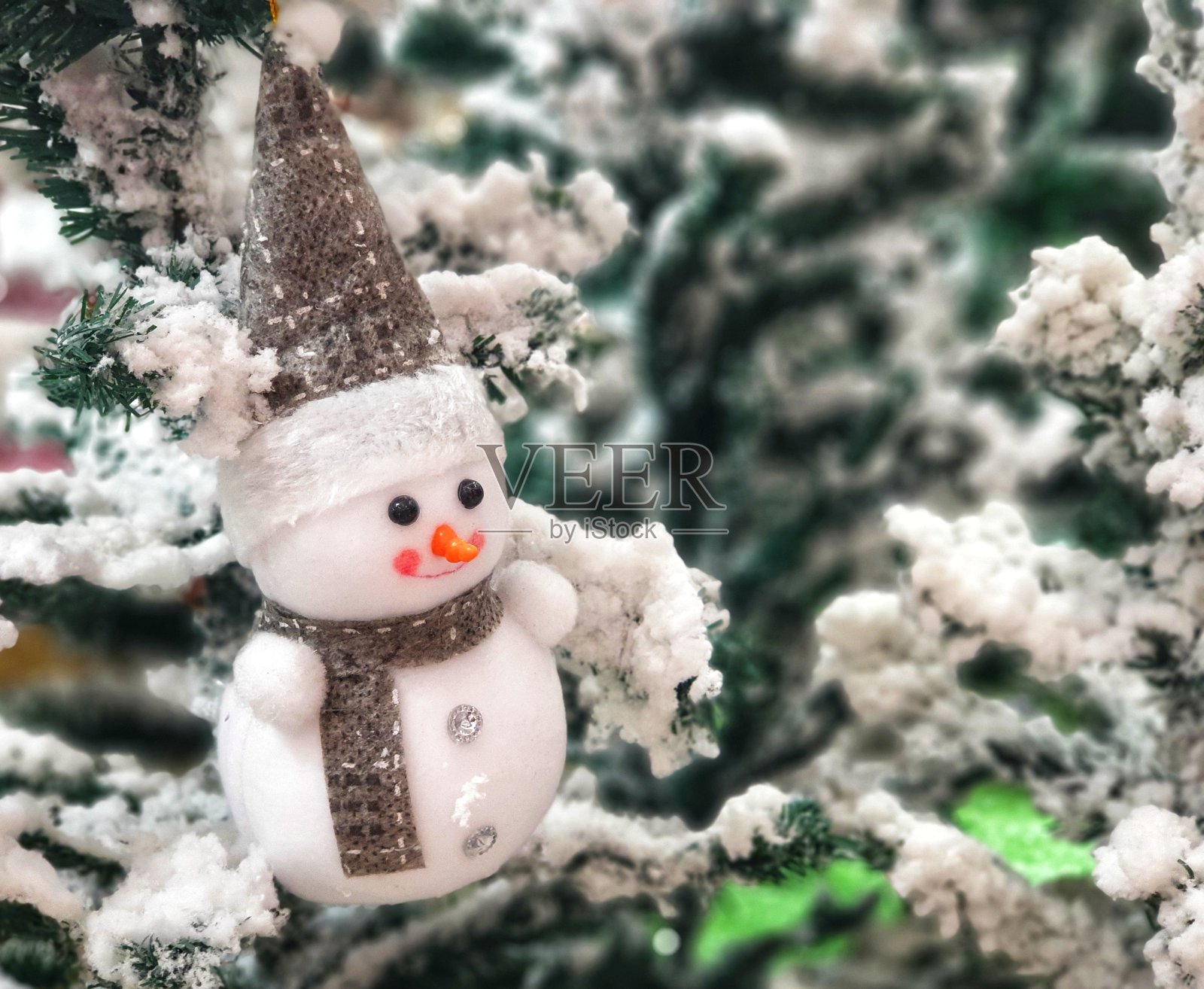 圣诞树上装饰着雪人的装饰品。照片摄影图片