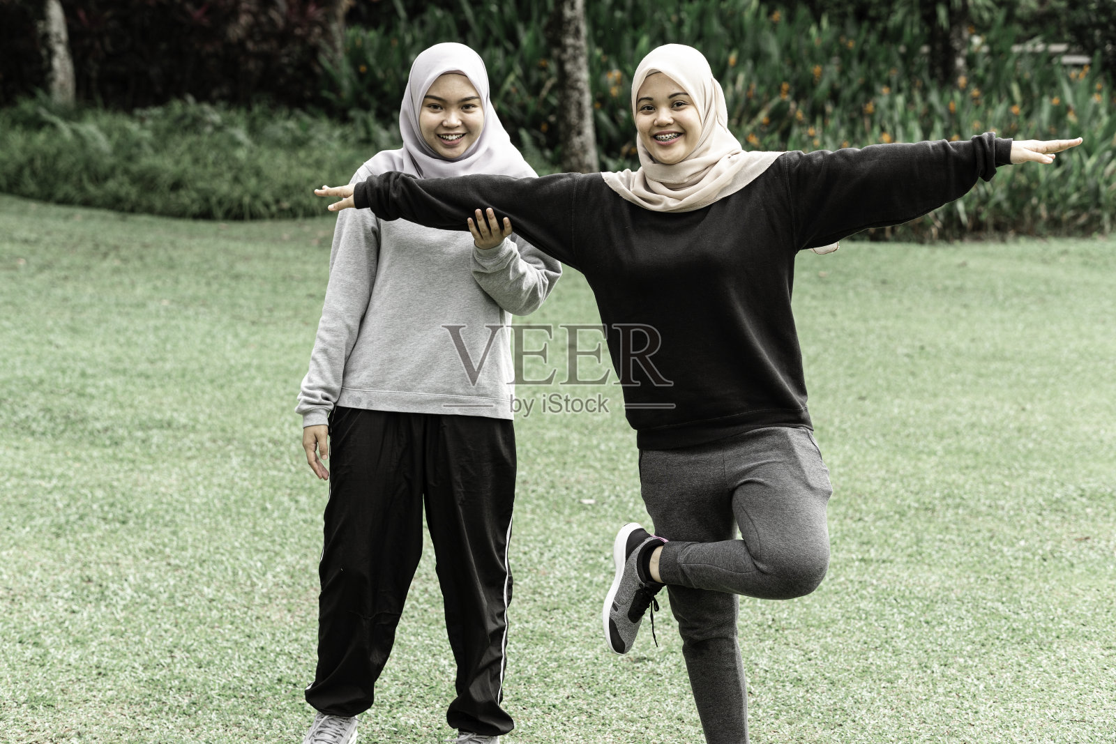阳光明媚的日子里在公园锻炼的漂亮穆斯林青少年照片摄影图片