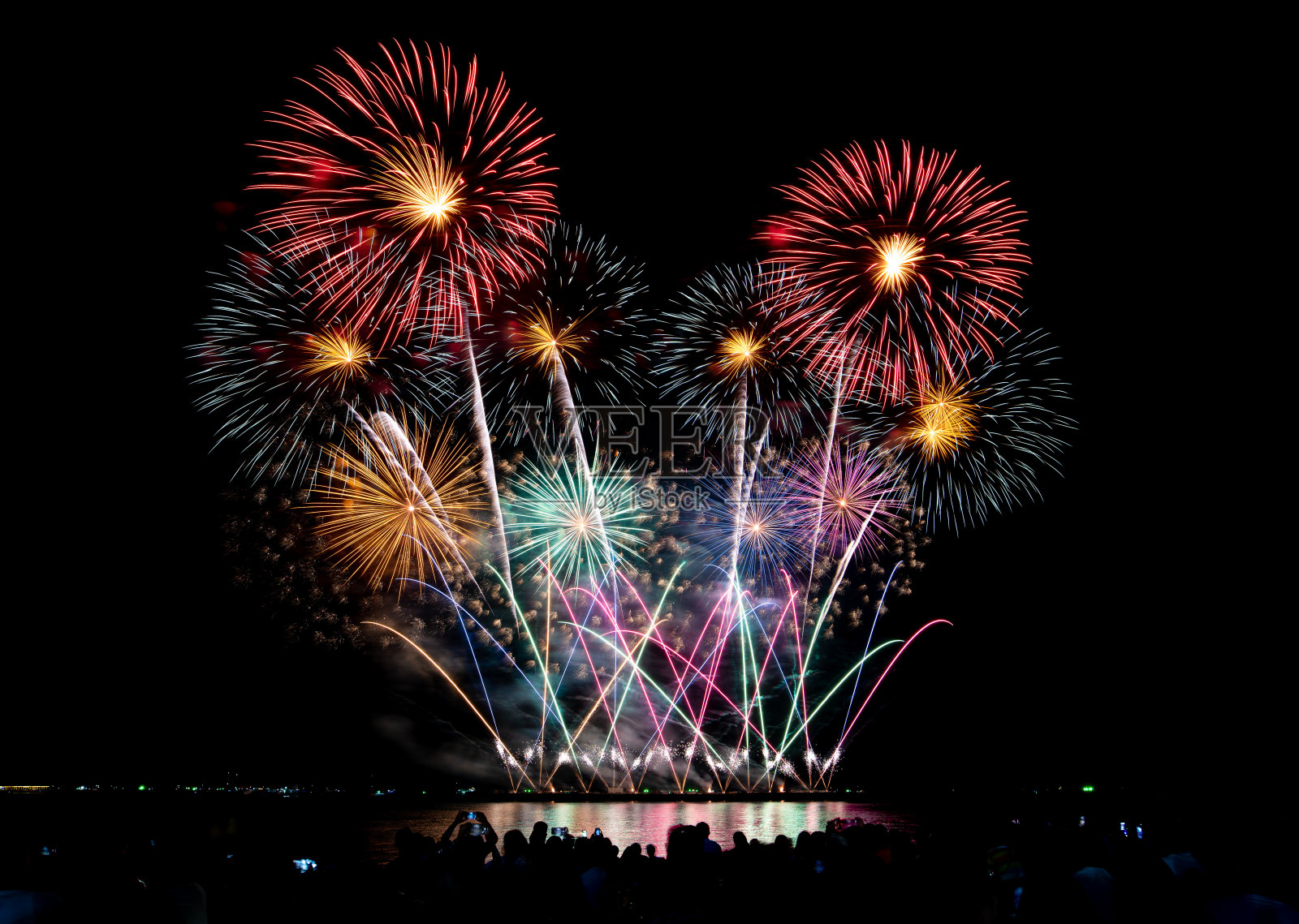 烟花照亮天空,人群观看烟花和庆祝圣诞和新年设计照片摄影图片
