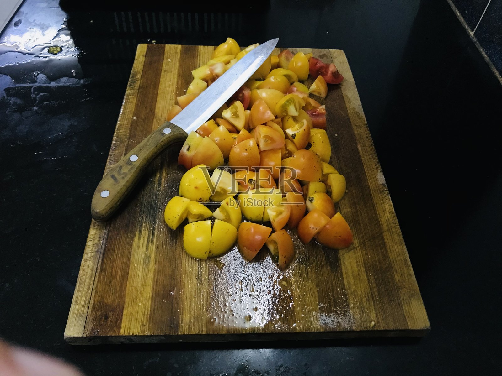 用刀把番茄切在砧板上照片摄影图片