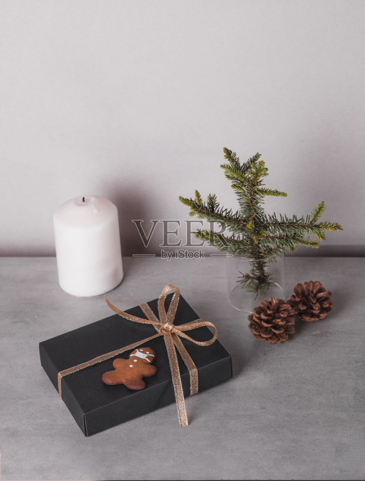 圣诞组成。礼品,黑色和金色的装饰在灰色的石头背景。饼干的形状是一个戴面具的人。新冠肺炎大流行背景下的假日概念照片摄影图片