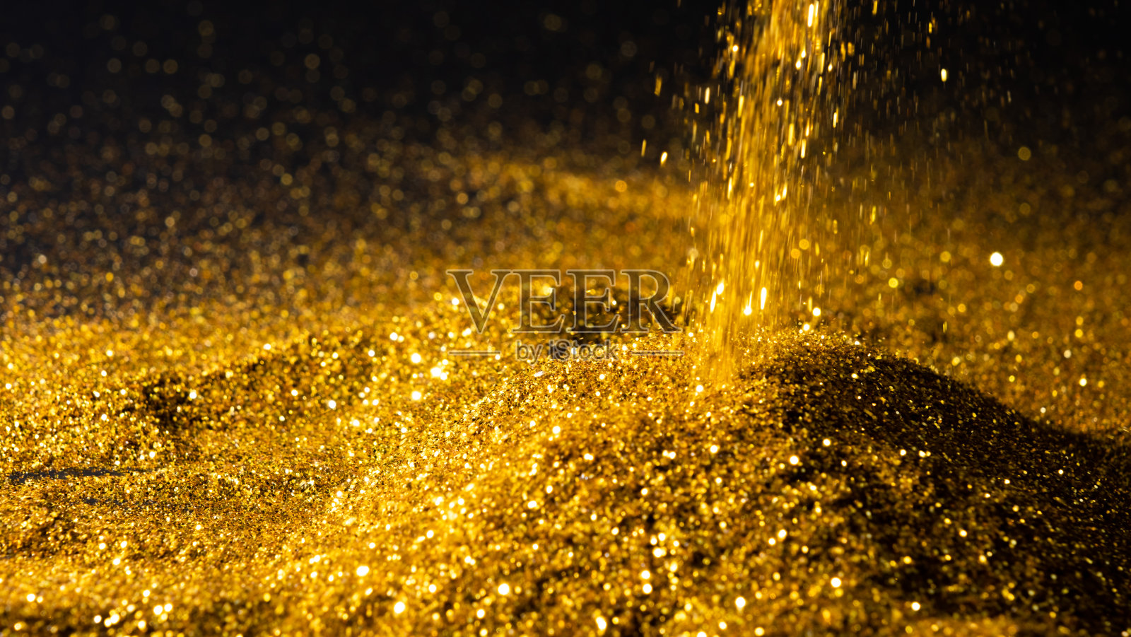 将闪闪发光的金粉洒在地面和黑色的背景上照片摄影图片