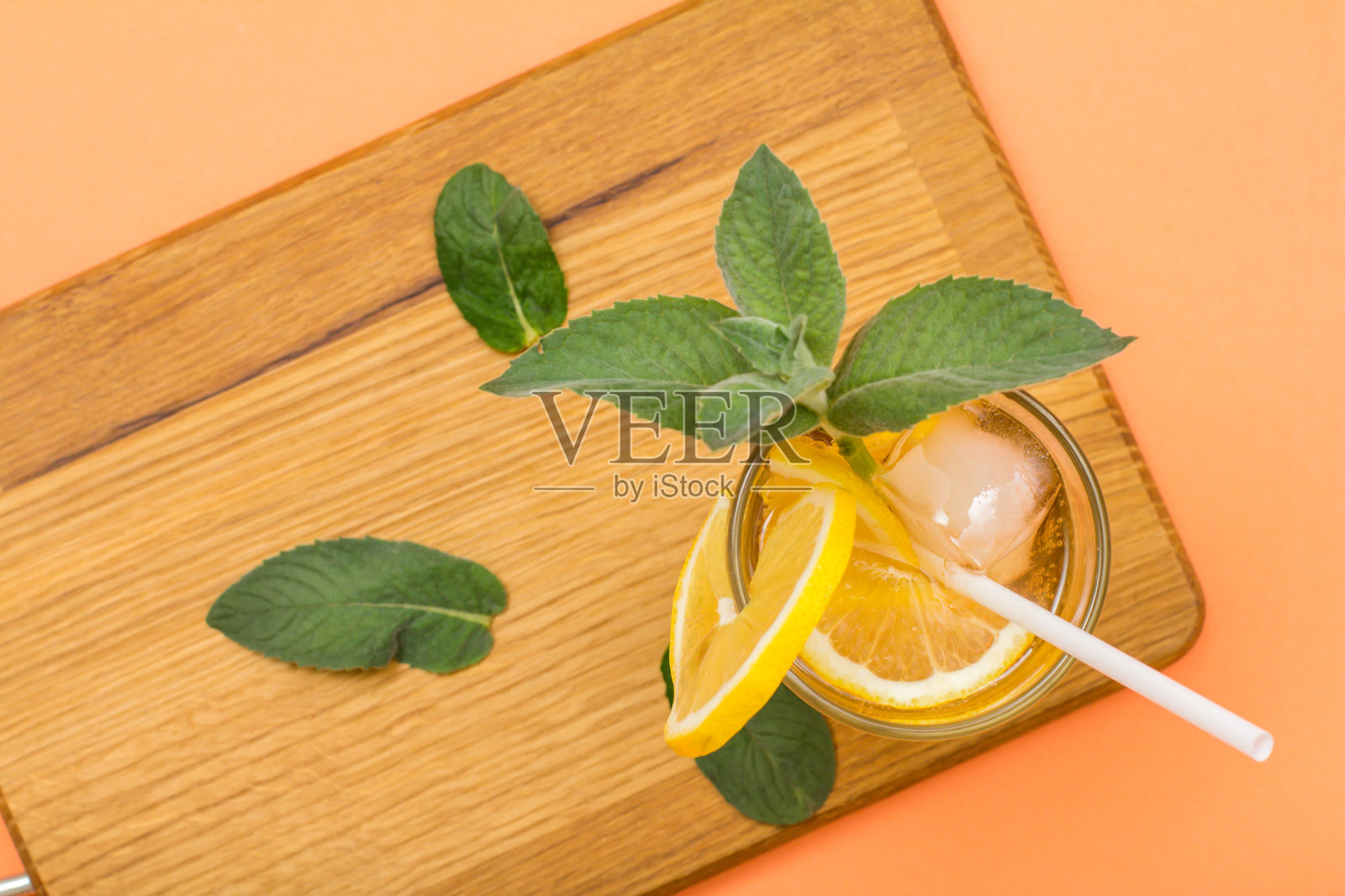 清凉的夏季柠檬水,冰和柠檬片,装饰薄荷叶在高脚杯。照片摄影图片