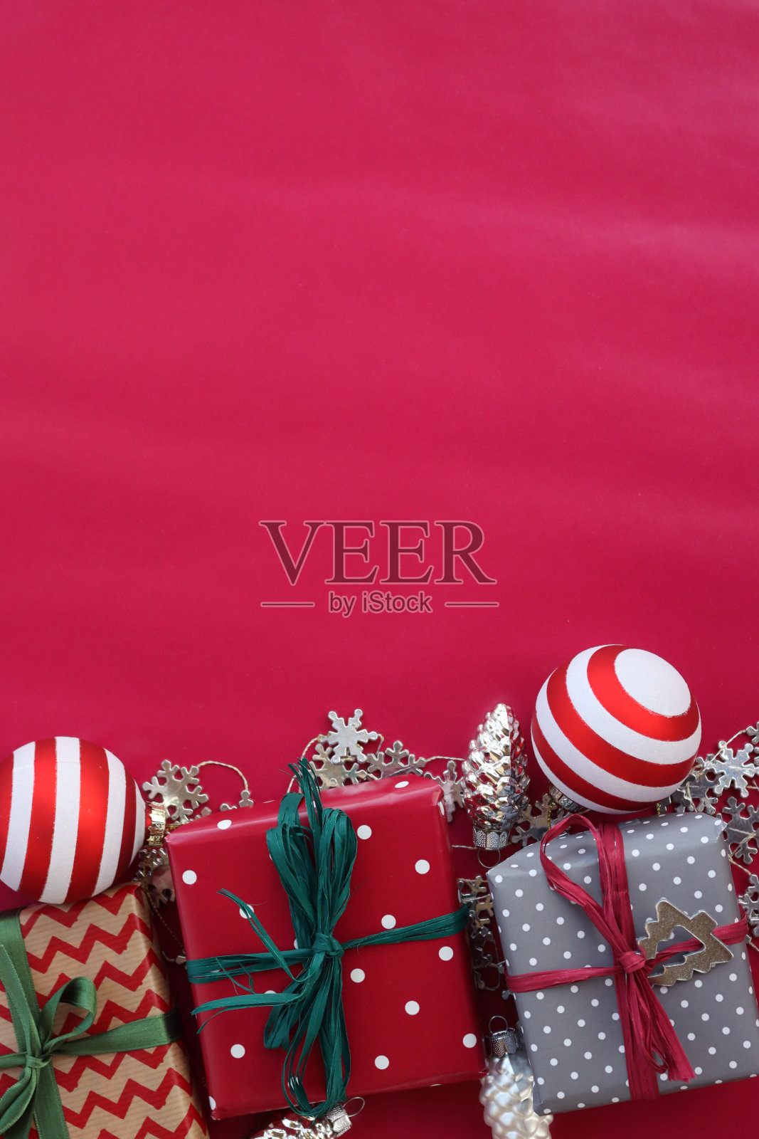 不同的圣诞礼品盒上有条纹玻璃球和银色装饰的红色照片摄影图片