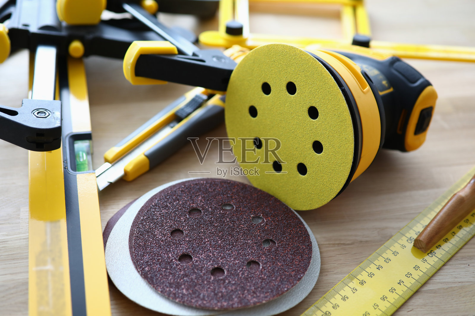 修理和施工用的尺子、磨床和量具放在棕色的桌子上。照片摄影图片