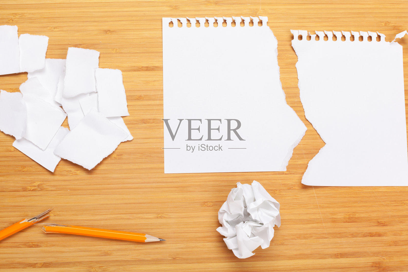 木桌上的白色记事本。在记事本周围放着许多皱巴巴的纸照片摄影图片