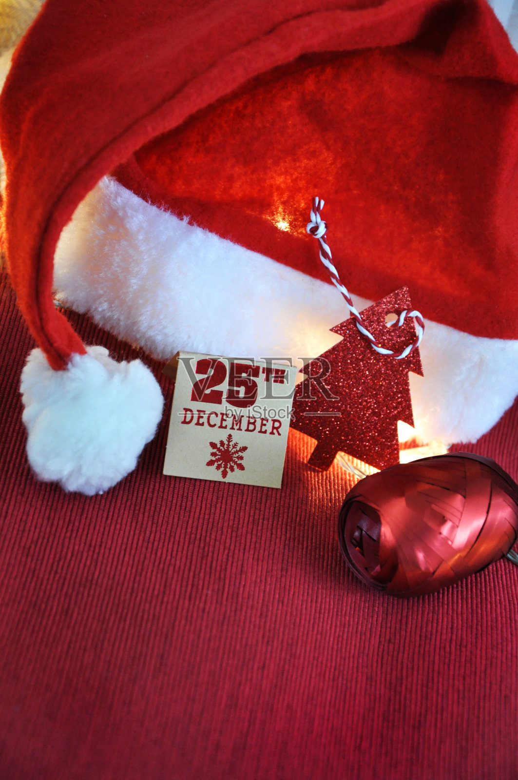 圣诞日期纸标签与圣诞帽在红色背景照片摄影图片