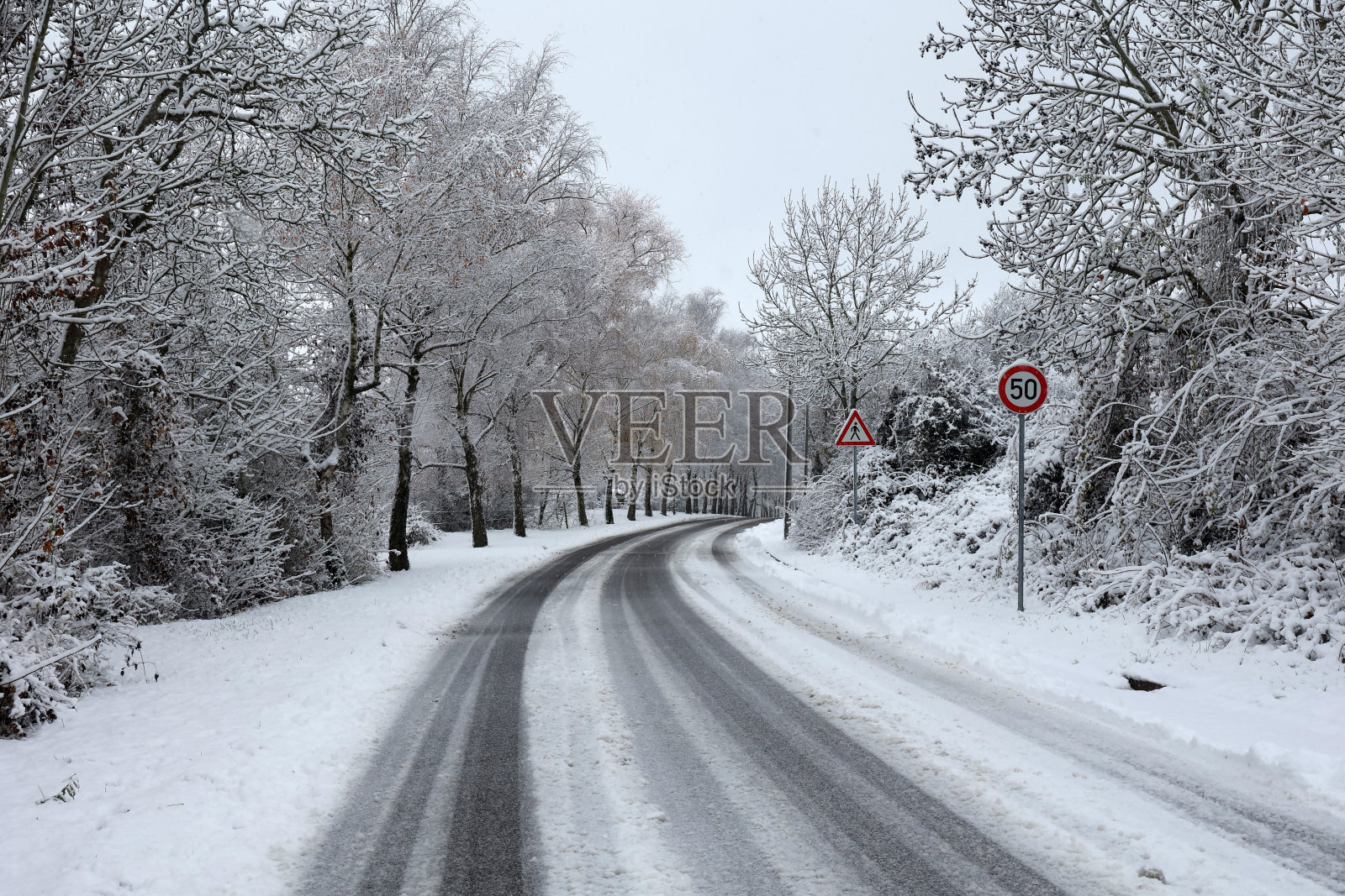 冬天在滑溜溜的雪路上的危险转弯照片摄影图片