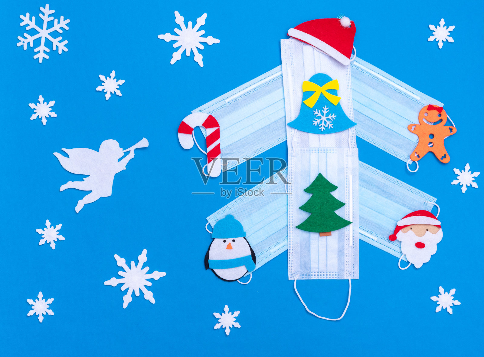 创意圣诞树由医用面具制成,装饰有新年玩具、白色天使和雪花照片摄影图片