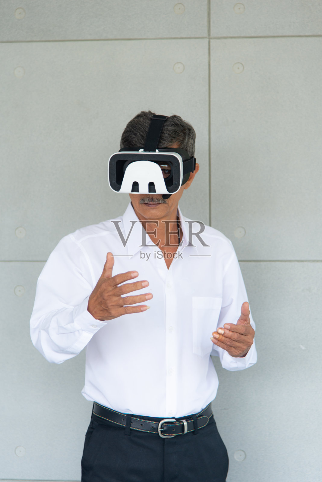 亚洲男子与白衬衫玩游戏,使用虚拟现实设备在客厅照片摄影图片