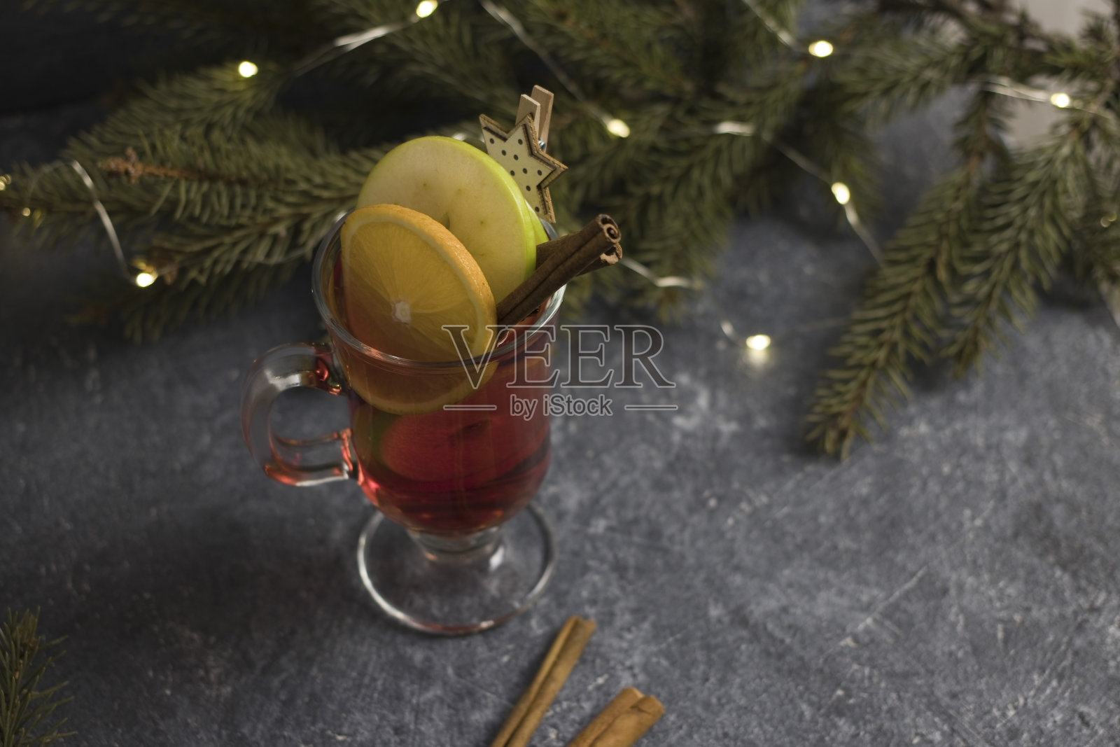 一杯热葡萄酒,香料,肉桂,和圣诞树在黑色的背景照片摄影图片