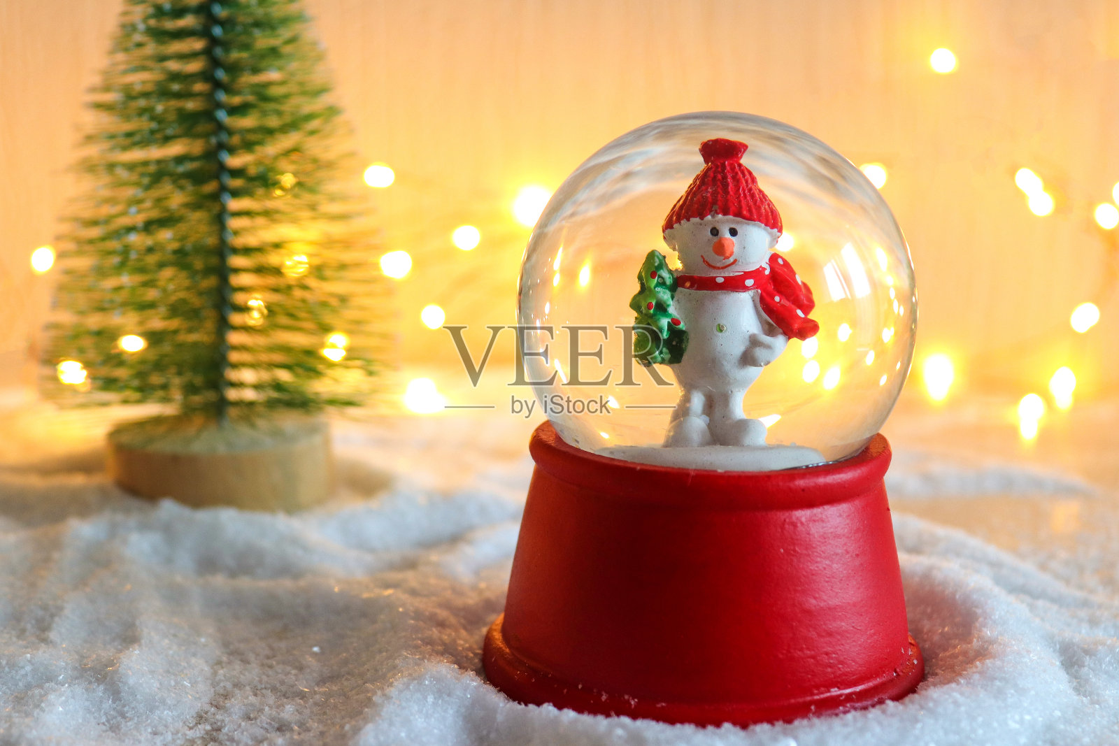 美丽的圣诞节或新年明信片与选择性的焦点。用圣诞树和散焦模糊的节日背景映衬着雪球和雪人。新年假期的背景。特写镜头照片摄影图片