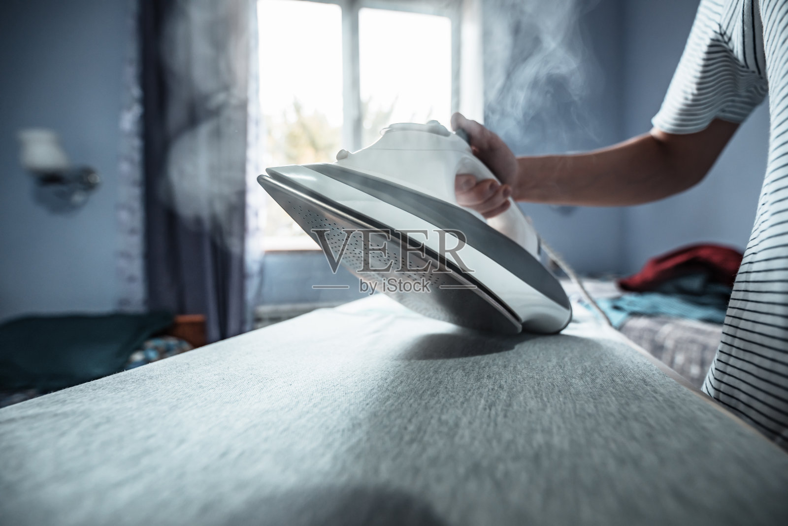 正在熨衣服的女人照片摄影图片