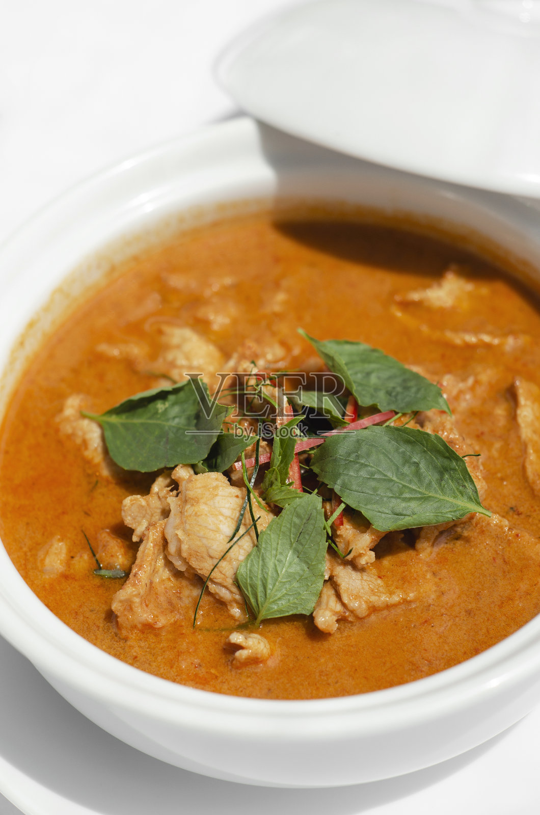 泰国普吉岛餐厅餐桌上的泰国辣咖喱猪肉和椰奶照片摄影图片