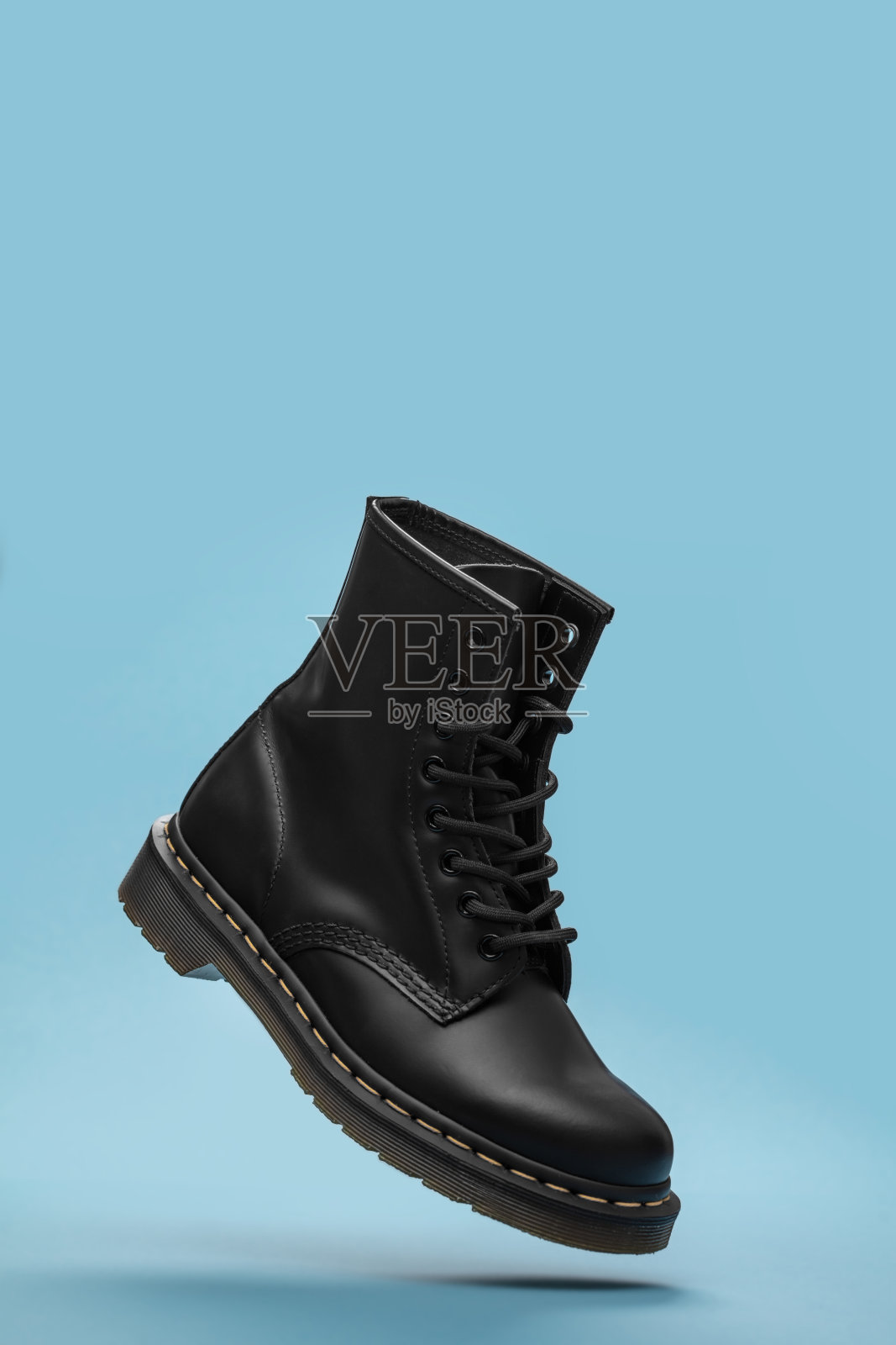 黑色的靴子在空中。时尚鞋静物。摄影棚里的时尚照片照片摄影图片