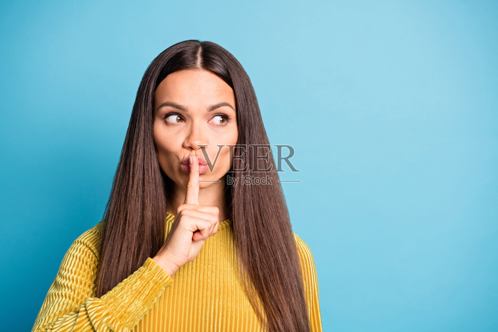 闭上嘴唇的照片肖像与手指看着空白空间孤立在柔和的蓝色背景照片摄影图片