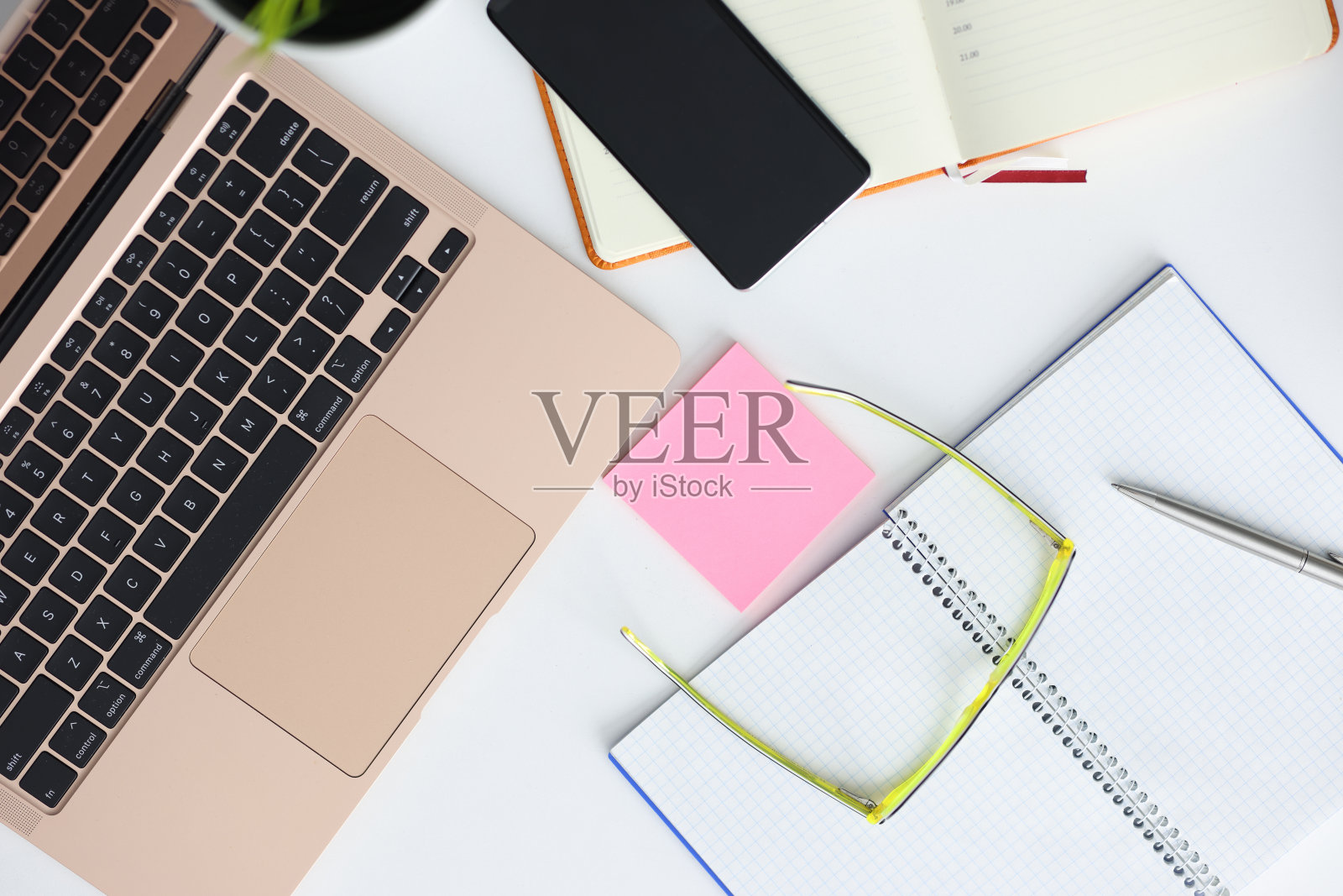 桌上笔记本,智能手机,眼镜,笔和记事本。照片摄影图片