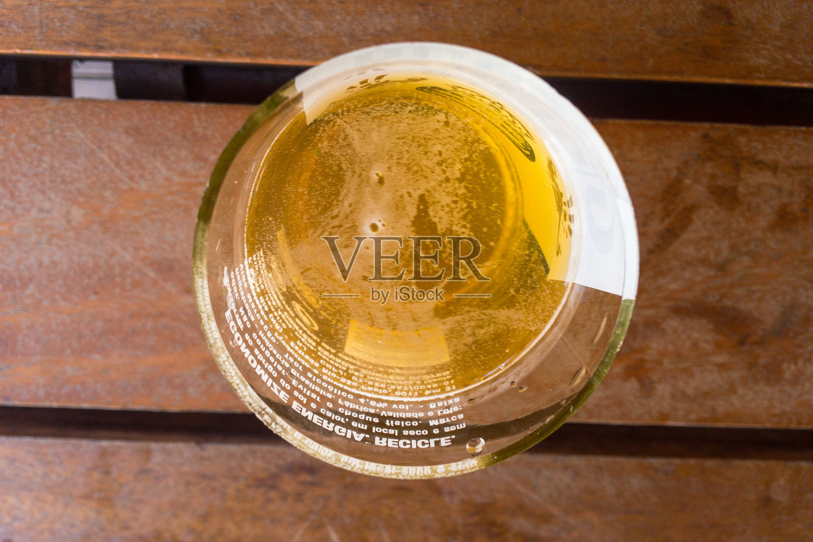 夏天,酒吧的木桌上放着一杯冰凉的啤酒。海滩上的酒吧。啤酒杯俯视图照片摄影图片