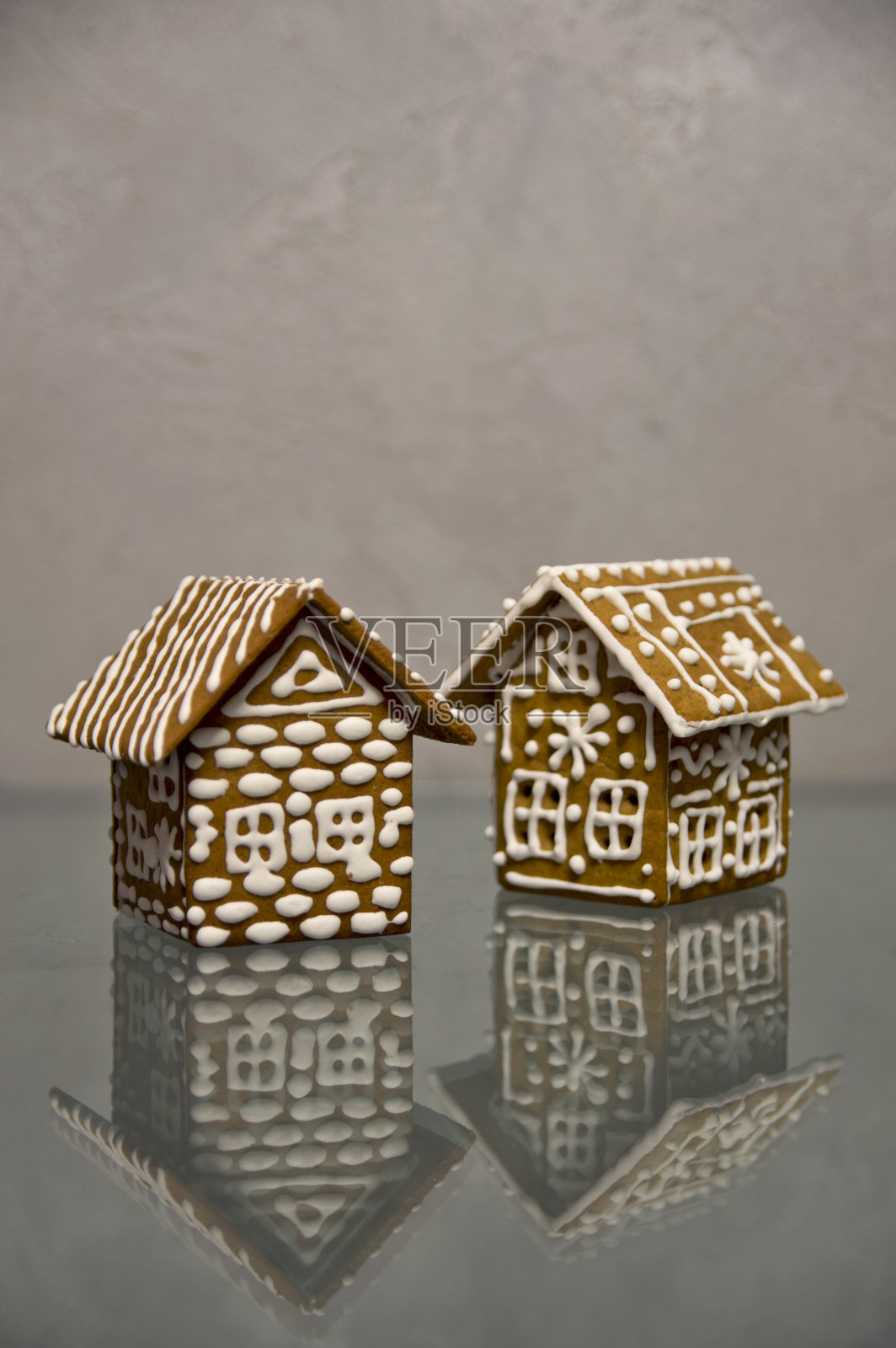 特写圣诞姜饼的两个房子反射在一个简单的背景玻璃照片摄影图片