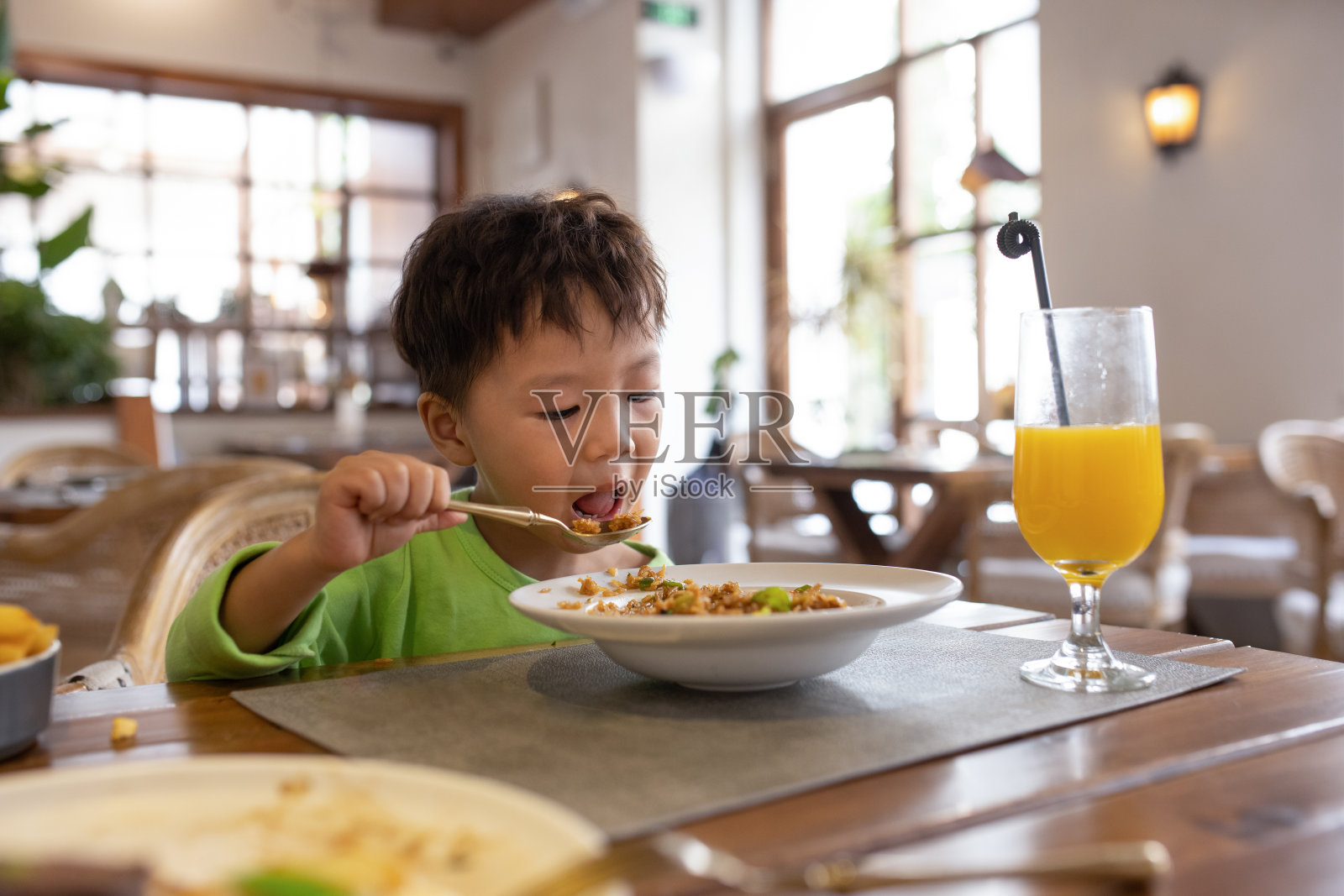 一个亚洲男孩在餐馆吃饭照片摄影图片