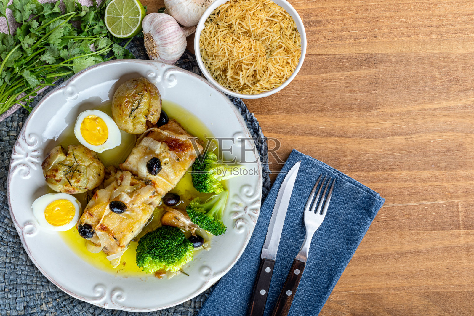 橄榄油烤鳕鱼腰肉,配土豆、花椰菜、煮鸡蛋和黑橄榄。这是葡萄牙的特色菜。前视图。空间的文本。照片摄影图片