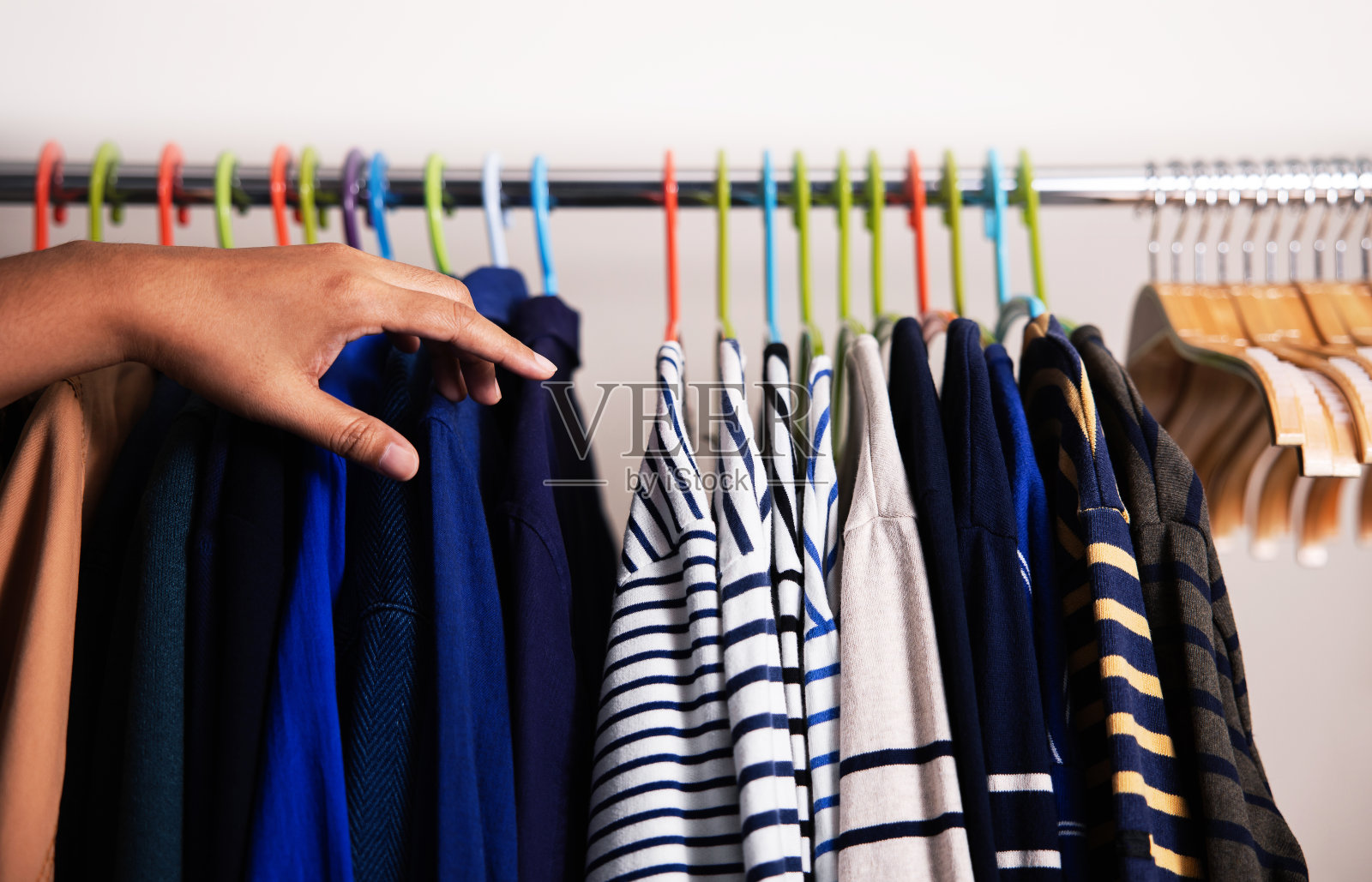 衣服架子上。男人的衣服挂在酒吧的白墙。时尚男士的时尚生活方式。选衬衫的人照片摄影图片