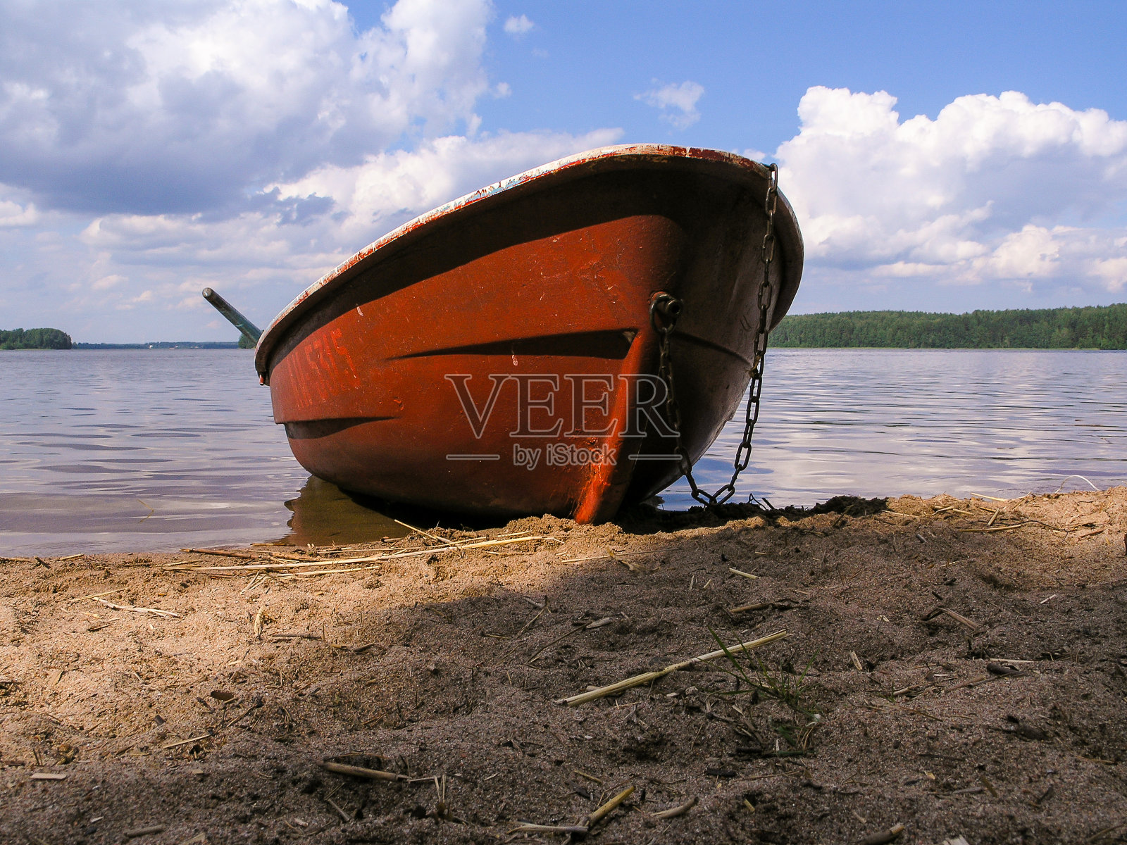 岸边沙滩上一条红棕色的旧船照片摄影图片