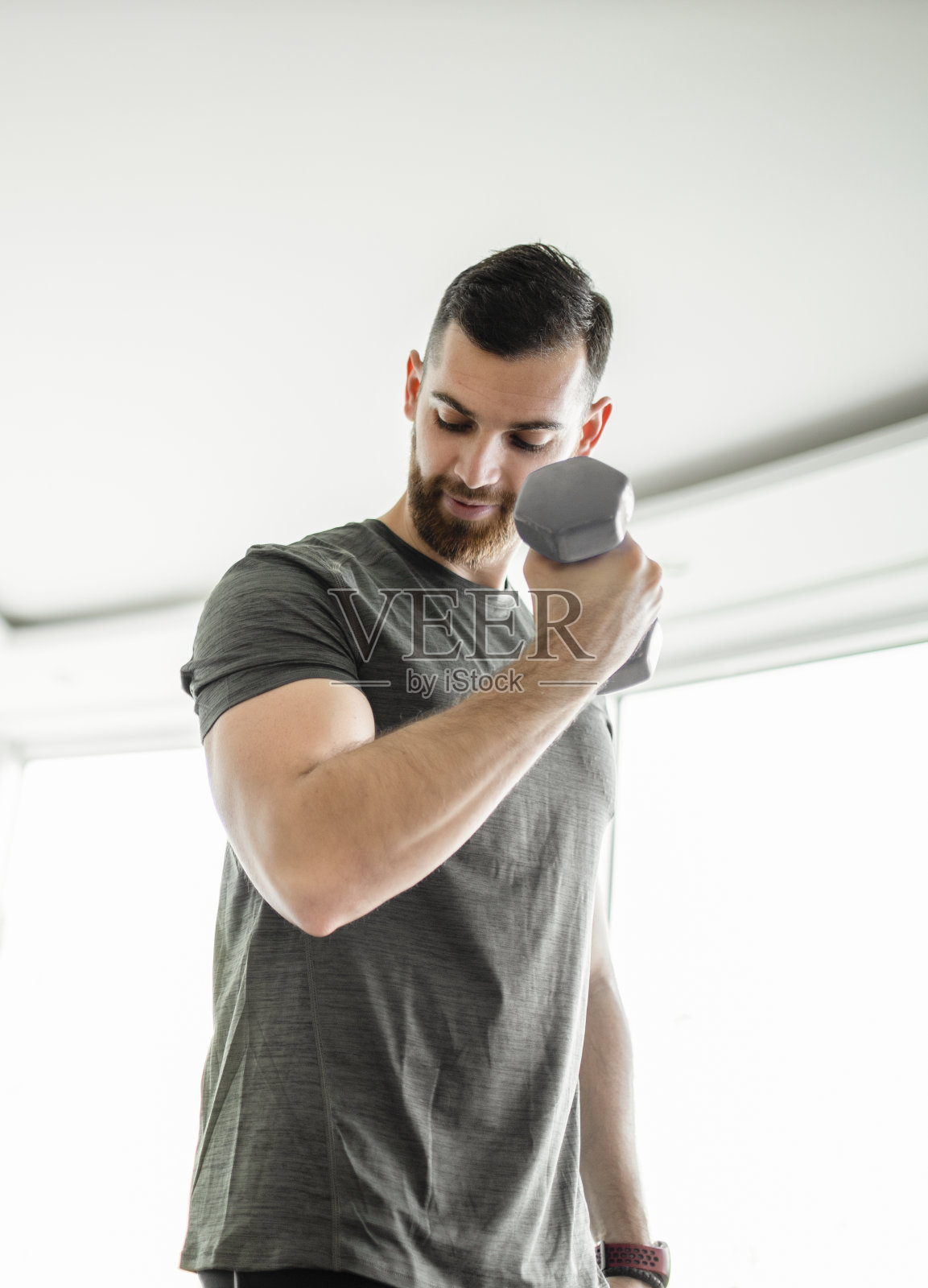 年轻的运动员在家里用哑铃进行运动训练照片摄影图片