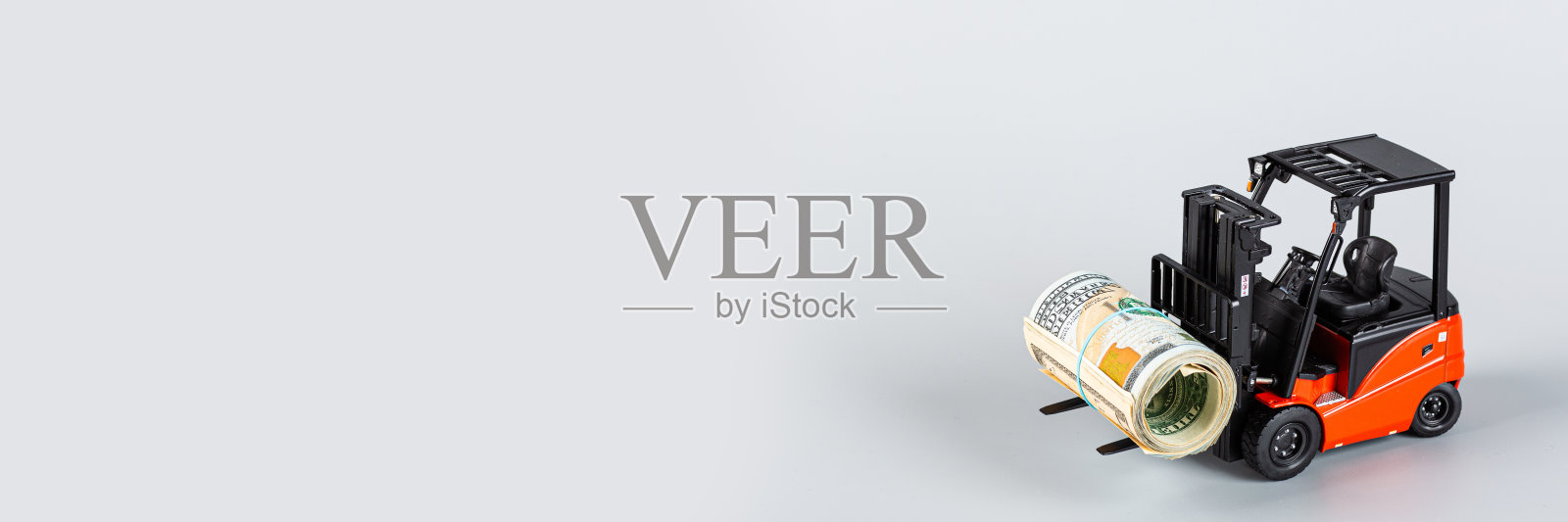 灰色背景上有一卷美元的叉车。提供最有力的资金援助,支持企业和民众应对新冠肺炎疫情。模型与复制空间照片摄影图片