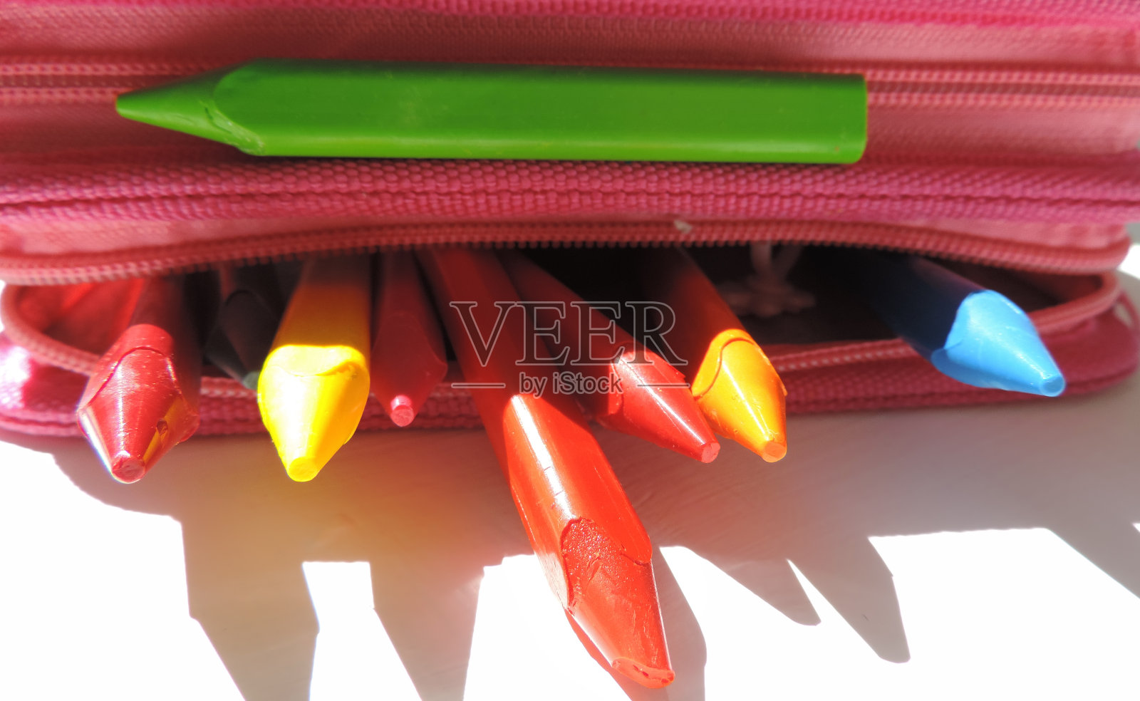 彩色蜡笔从粉红色铅笔盒中突出来照片摄影图片