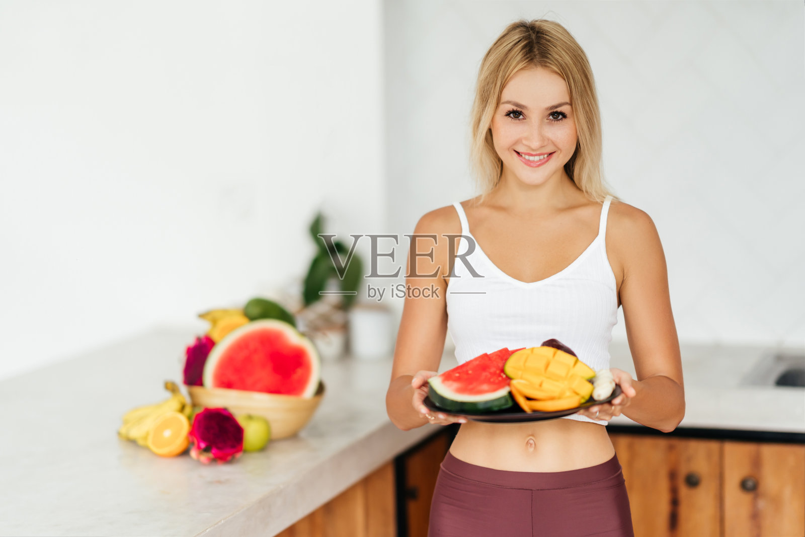 带着热带水果微笑的女人照片摄影图片