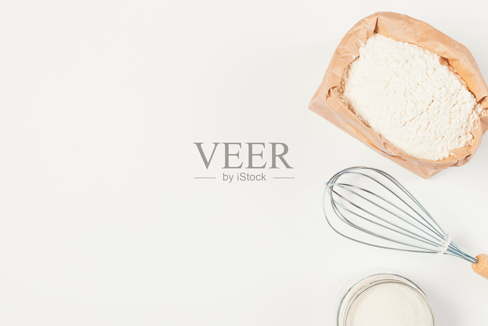 俯视图面粉旁边的搅拌袋和糖在白色的厨房桌子上照片摄影图片