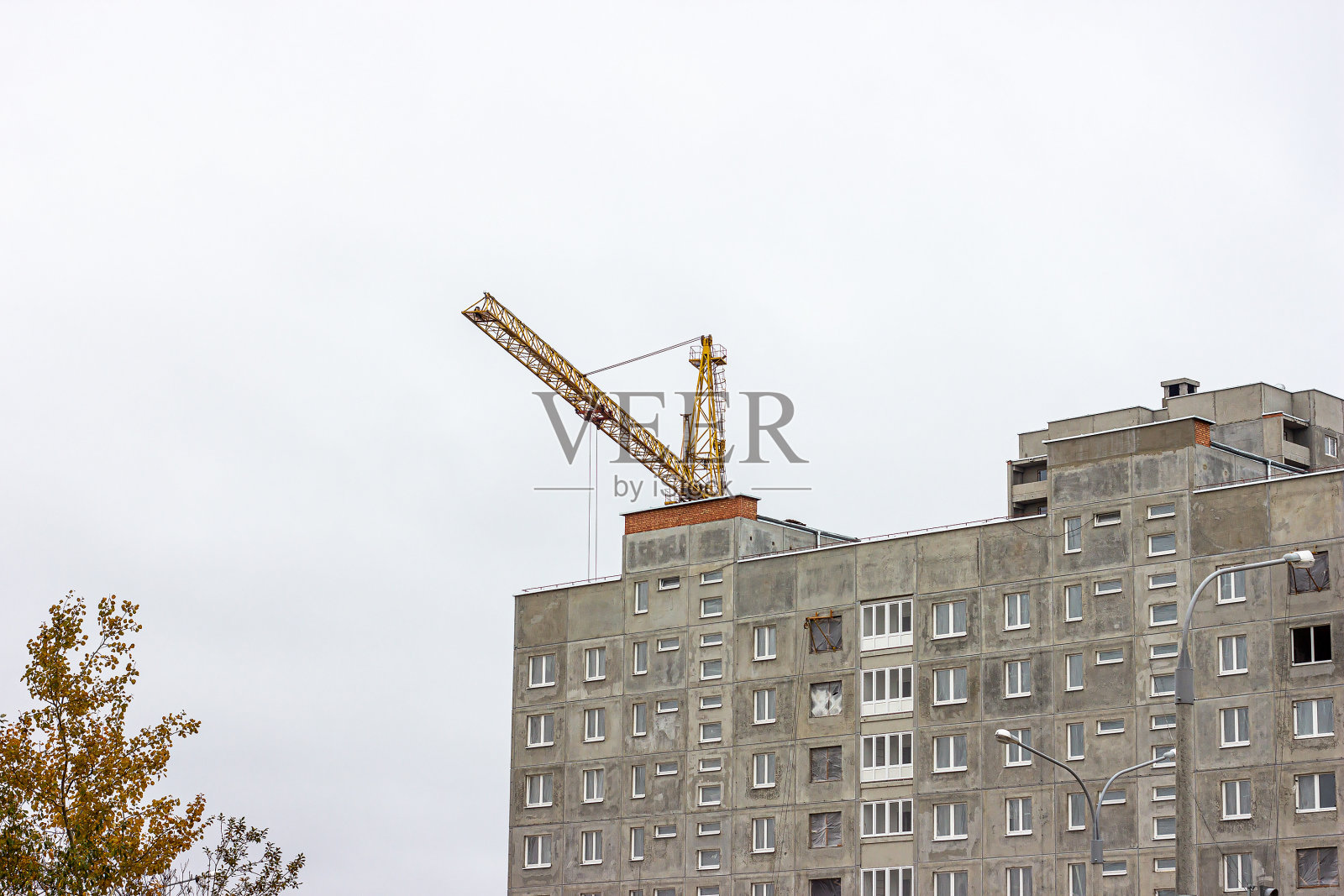 城市中高大的起重机建造灰色积木房屋的建筑工地照片摄影图片