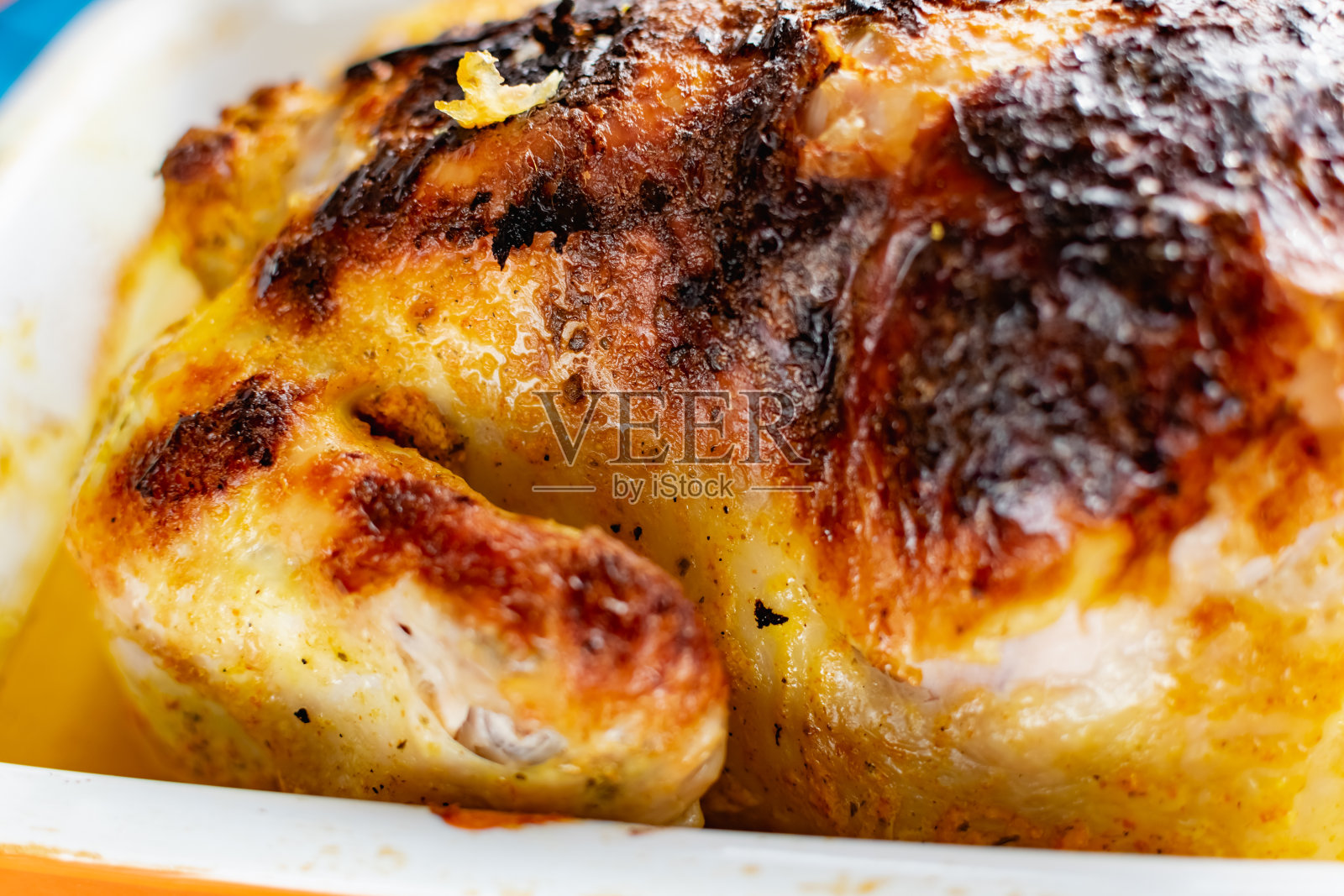 热烤鸡和美味的棕色油炸皮。煮炸过的家禽,用自己的汁液和油脂浇灌。照片摄影图片