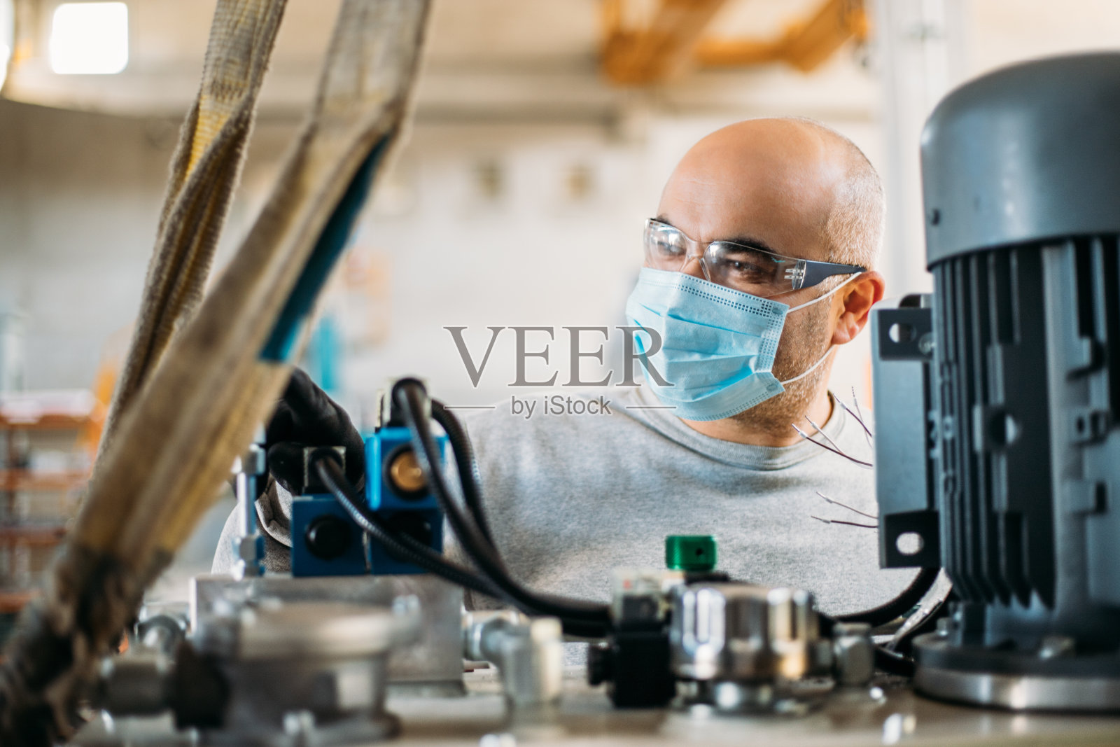 工厂里操作机器的高级工人照片摄影图片