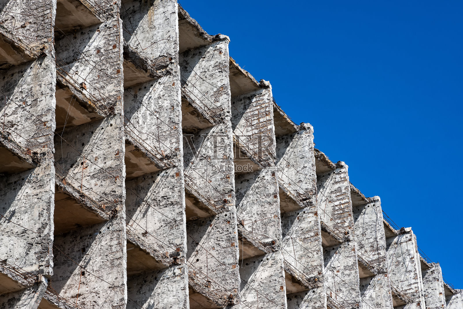 这是一座废弃的混凝土建筑的斜线碎片,背景是蓝天照片摄影图片