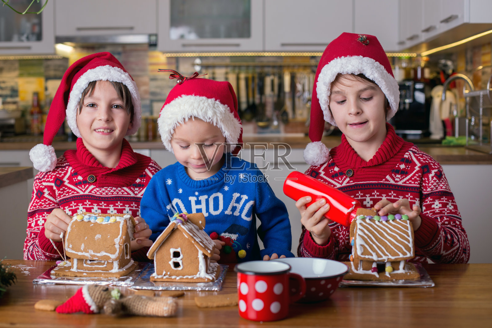 孩子们,男孩们,在妈妈的帮助下,在家里做姜饼照片摄影图片