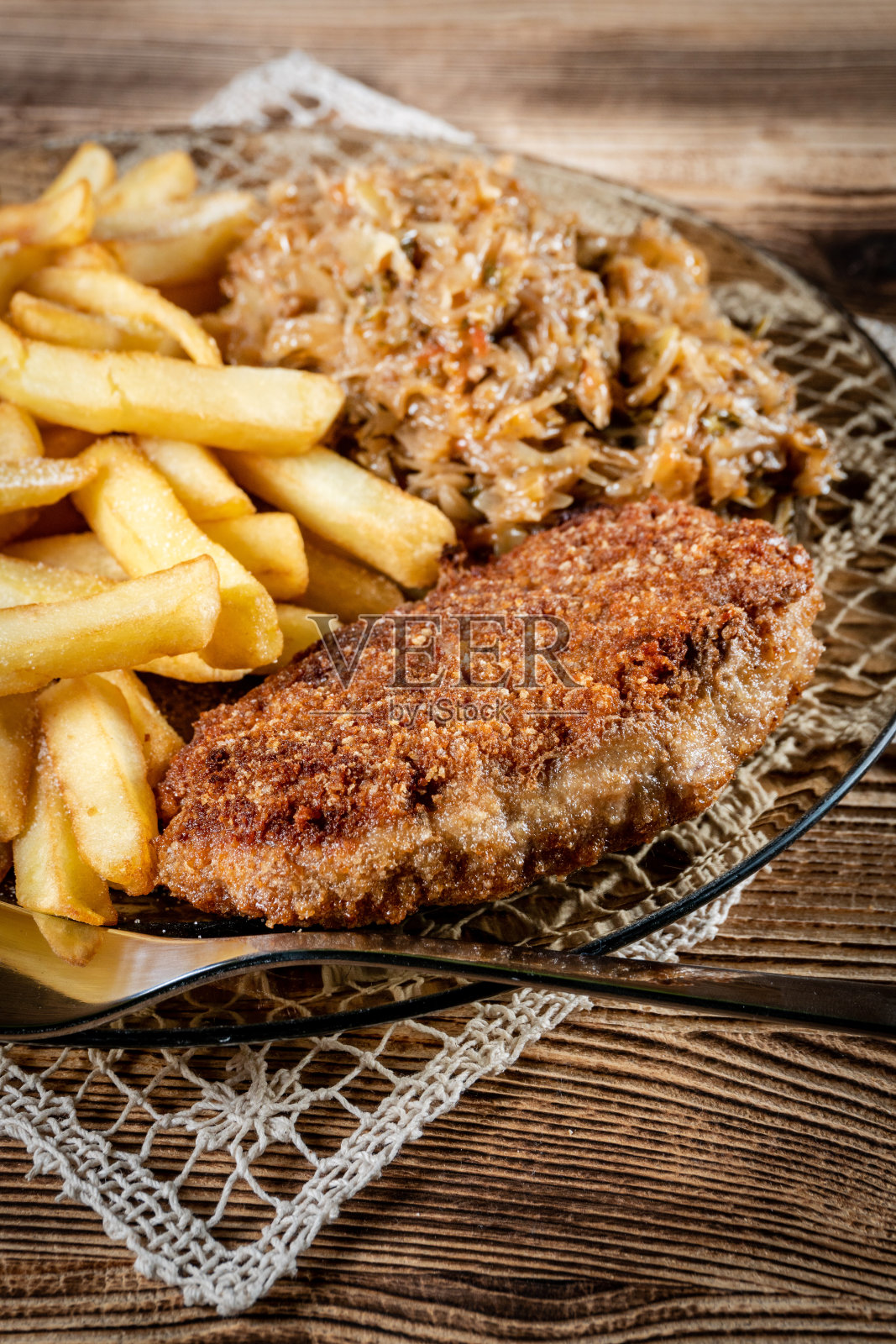 面包屑猪排配薯条和炖白菜。照片摄影图片