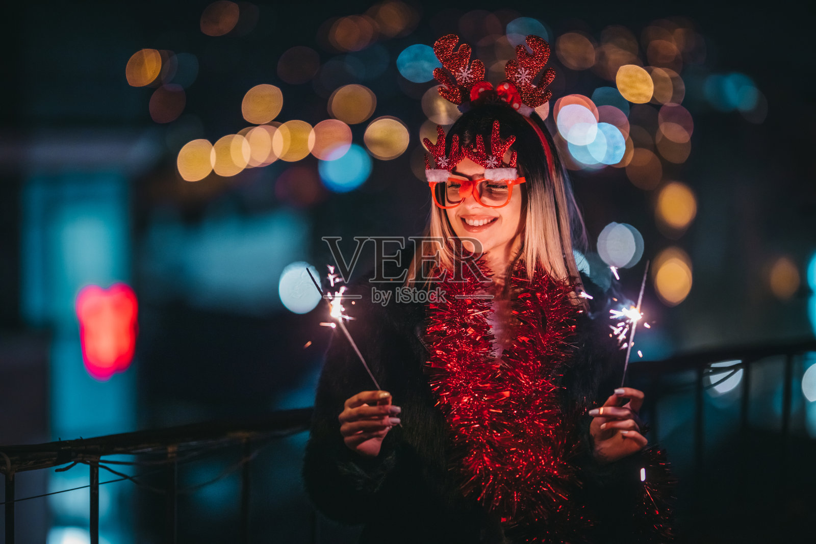 一个有圣诞洒水器的漂亮女人照片摄影图片